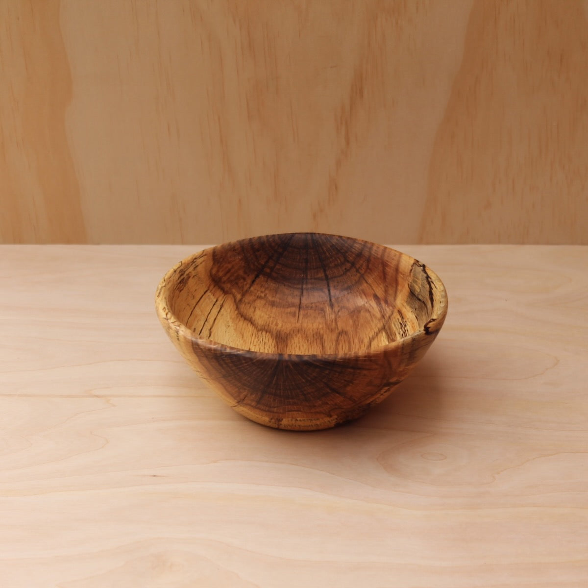 top of a hand made wooden bowl- pattern consists of dark brown, chocolate brown and yellow.