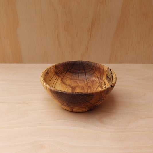 top of a hand made wooden bowl- pattern consists of dark brown, chocolate brown and yellow.