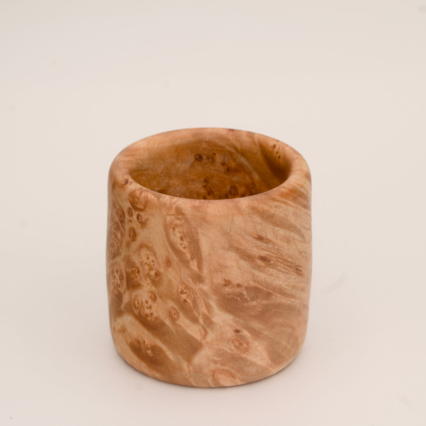 Maple burl wood shot glass on white background
