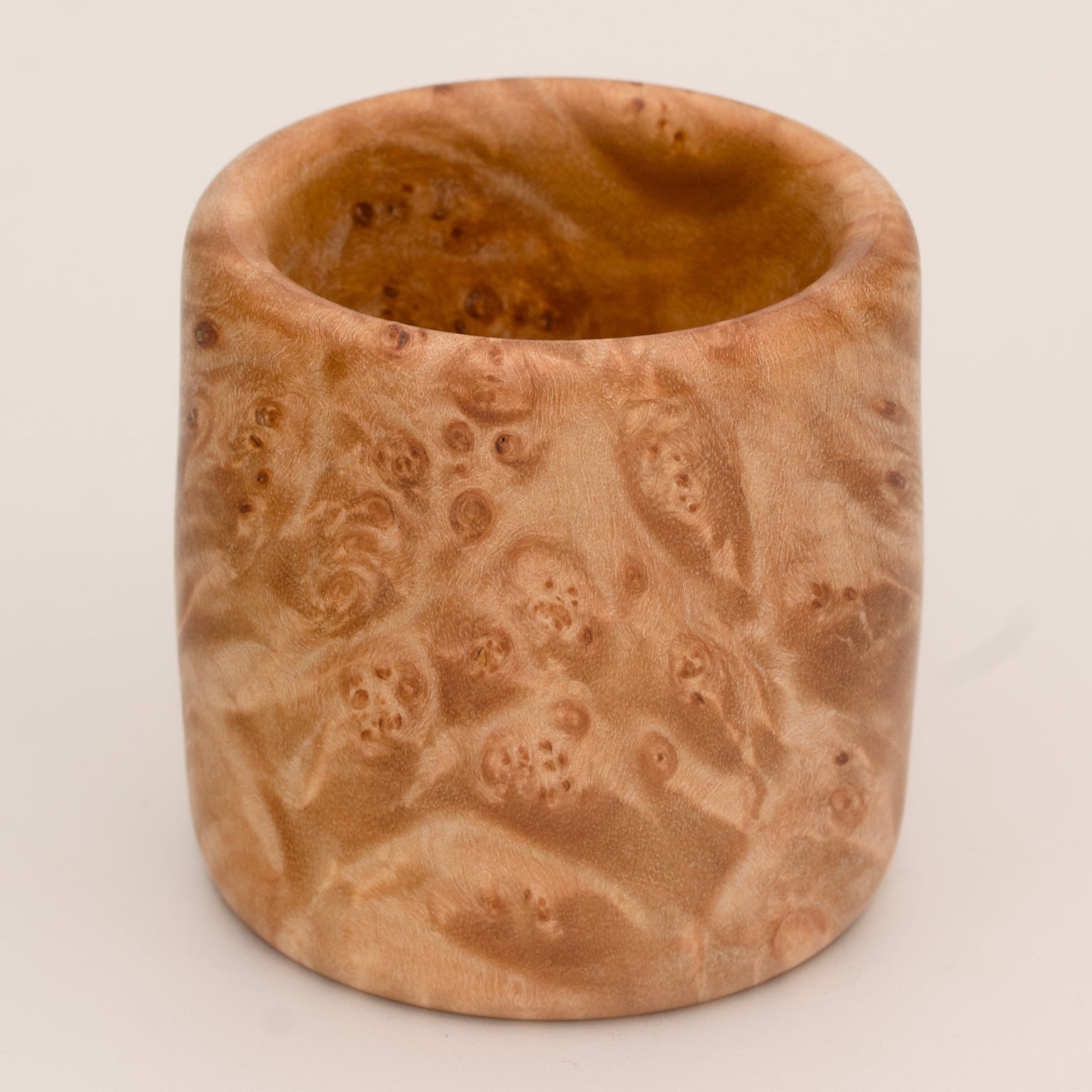 Maple burl wood shot glass on white background