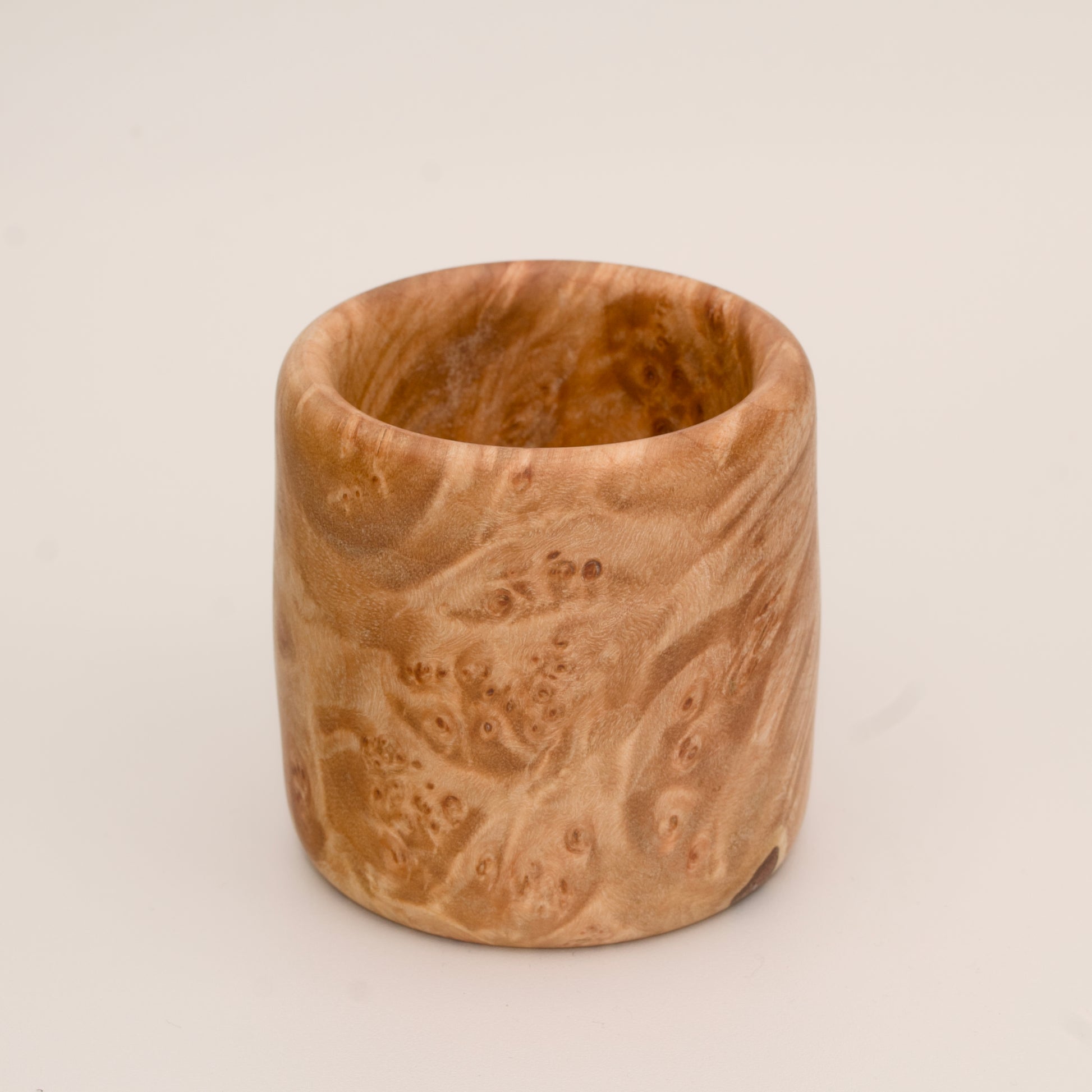 Maple burl wood shot glass on white background