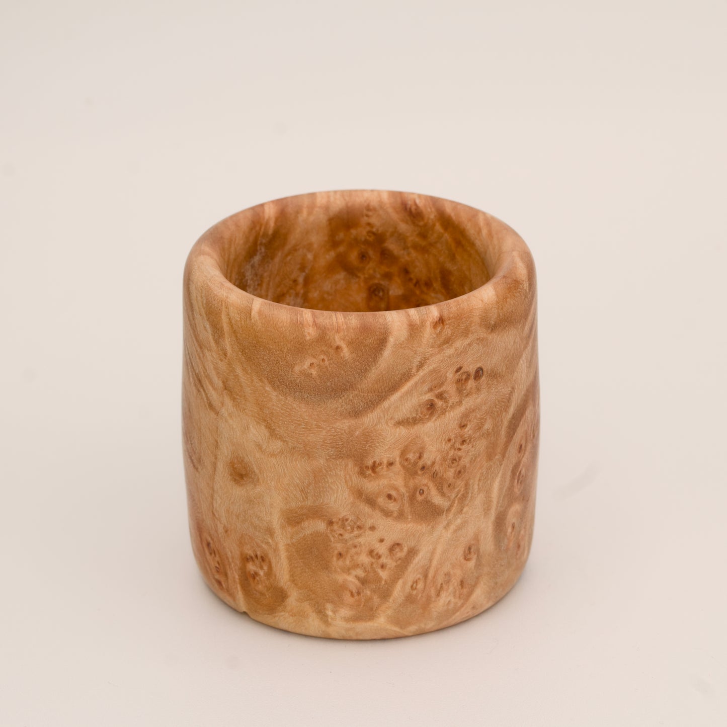 Maple burl wood shot glass on white background