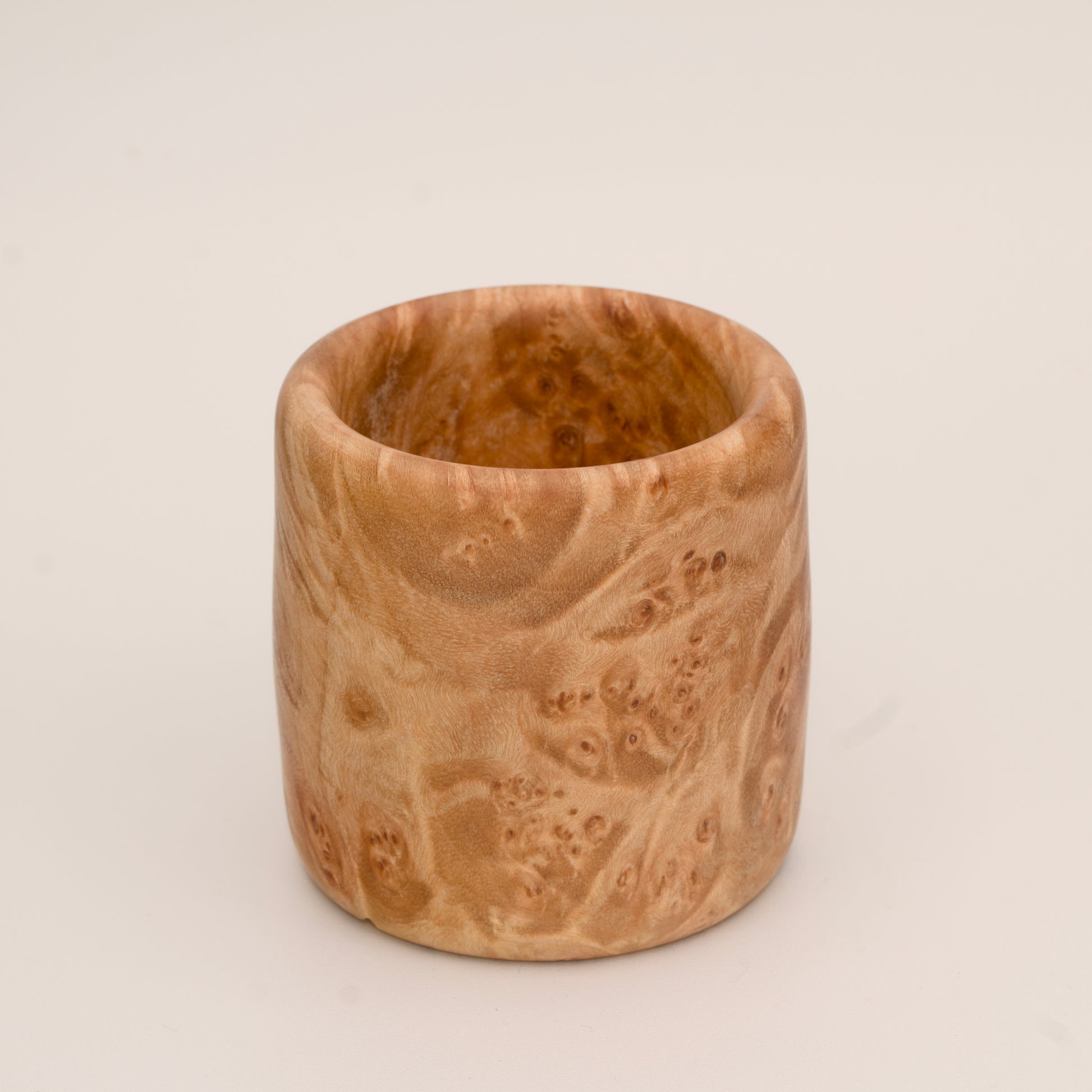 Maple burl wood shot glass on white background
