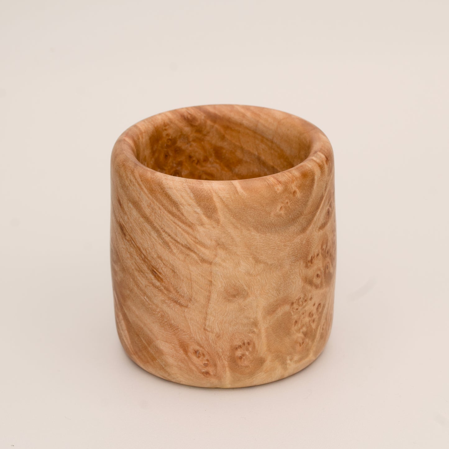 Maple burl wood shot glass on white background
