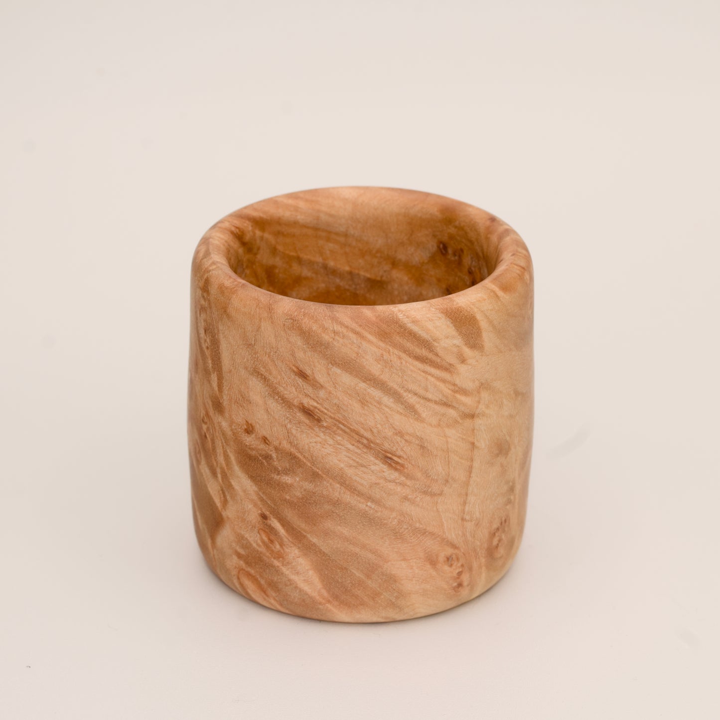 Maple burl wood shot glass on white background