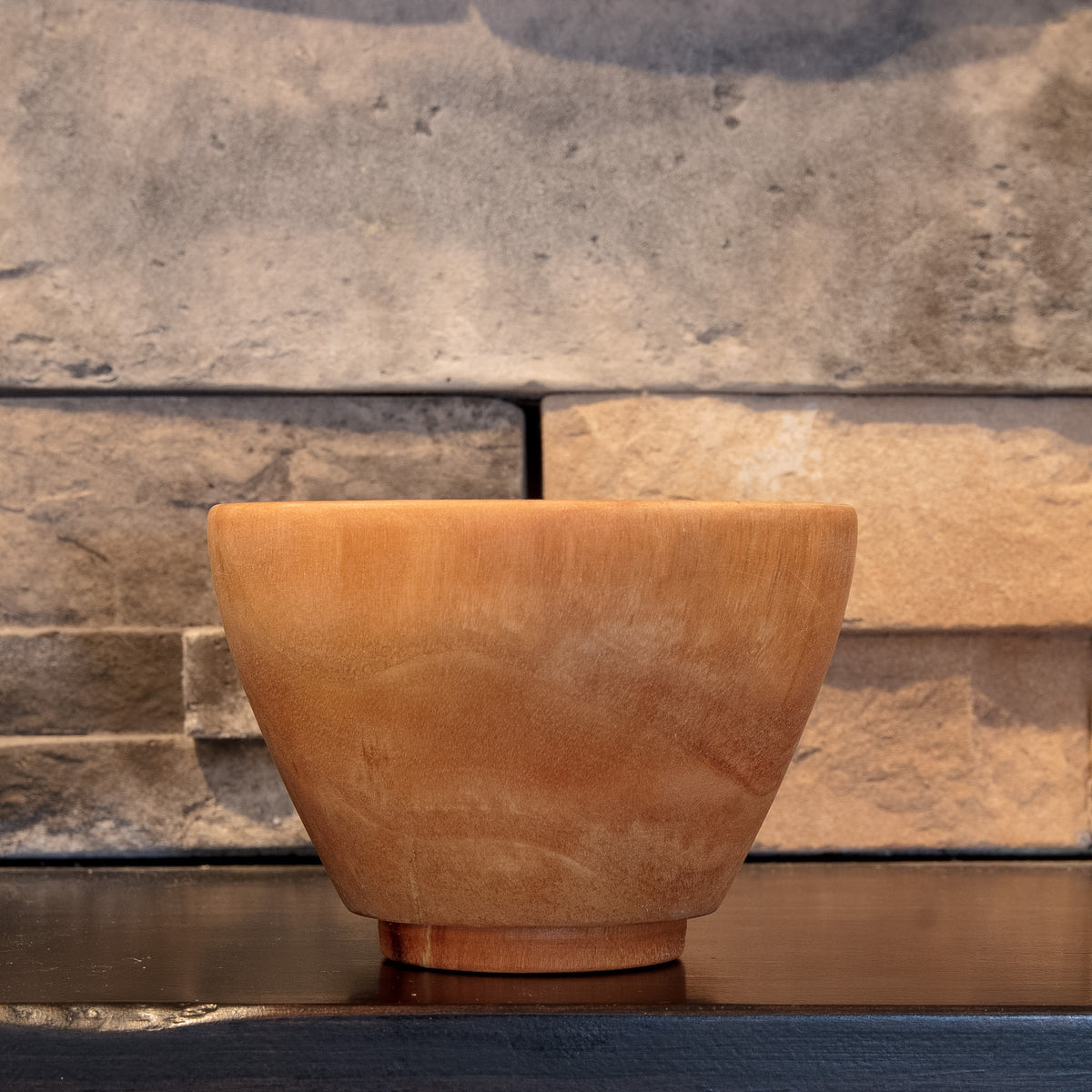 The Wood at Hand rice bowl showing a quieter exterior face with pale flowing grain and raised foot