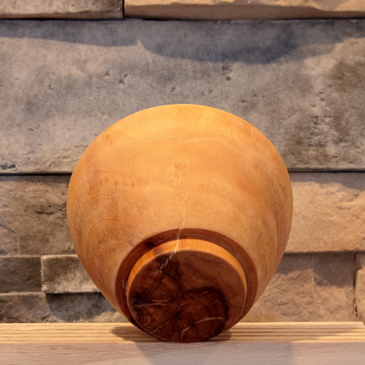 Underside of The Wood at Hand rice bowl showing its raised foot, dark end grain and natural checking