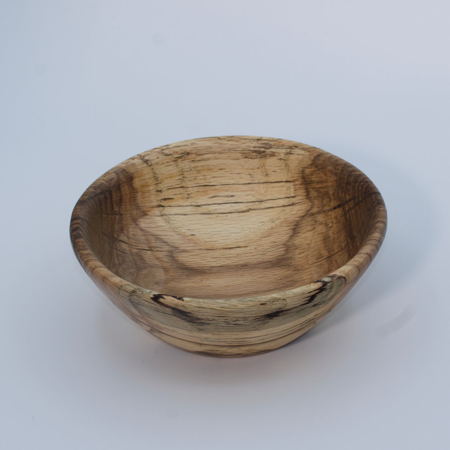 Wooden bowl with a natural, textured surface on a white background