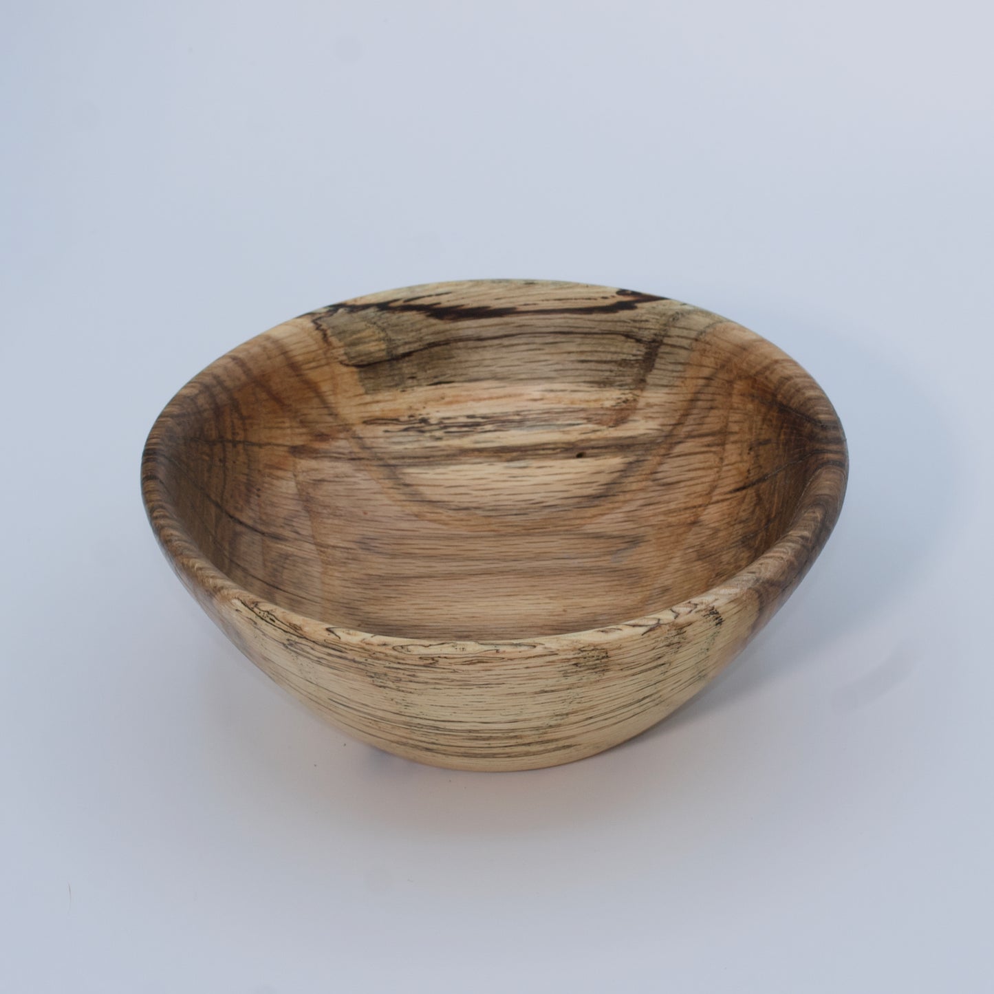 Wooden bowl with a natural, textured surface on a white background