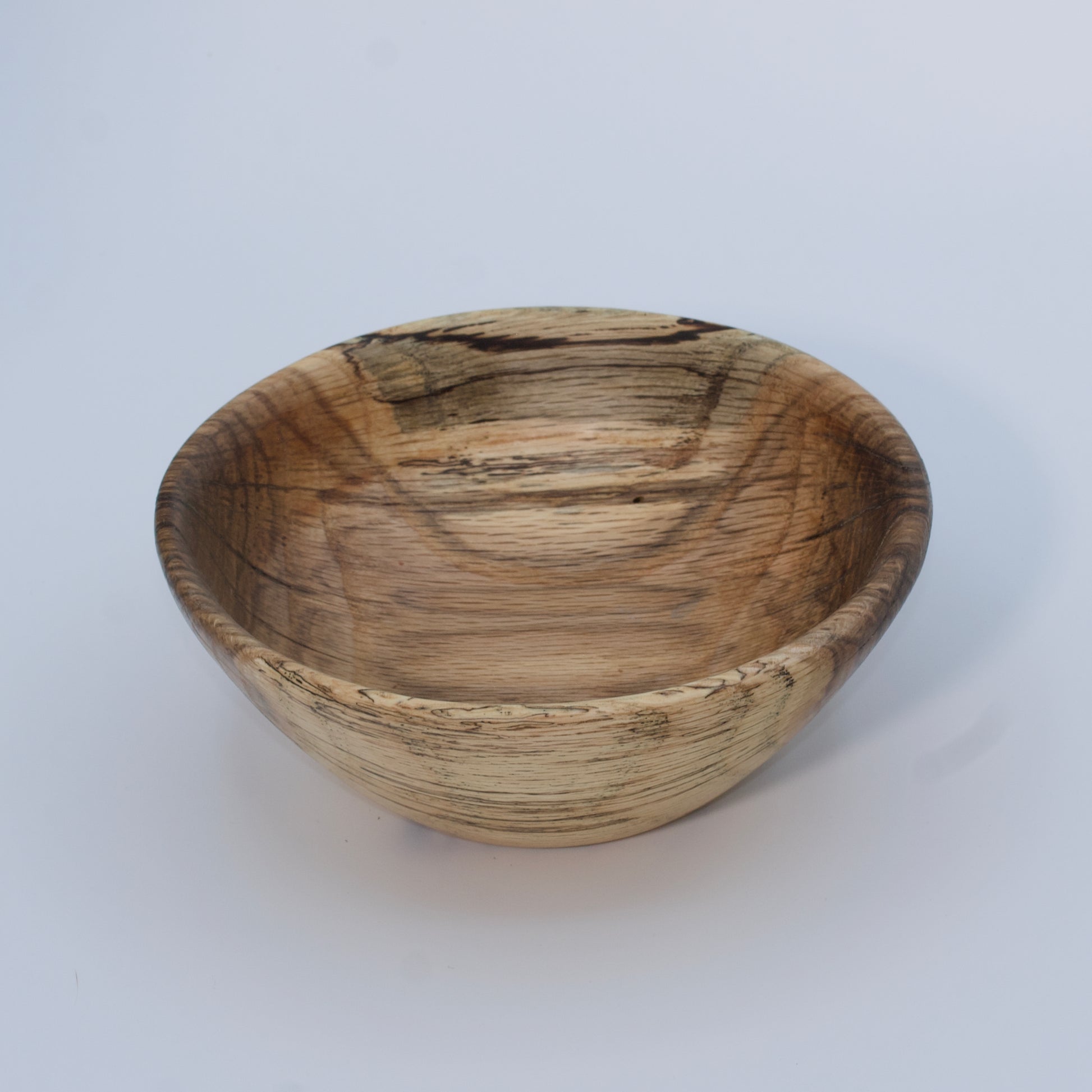 Wooden bowl with a natural, textured surface on a white background