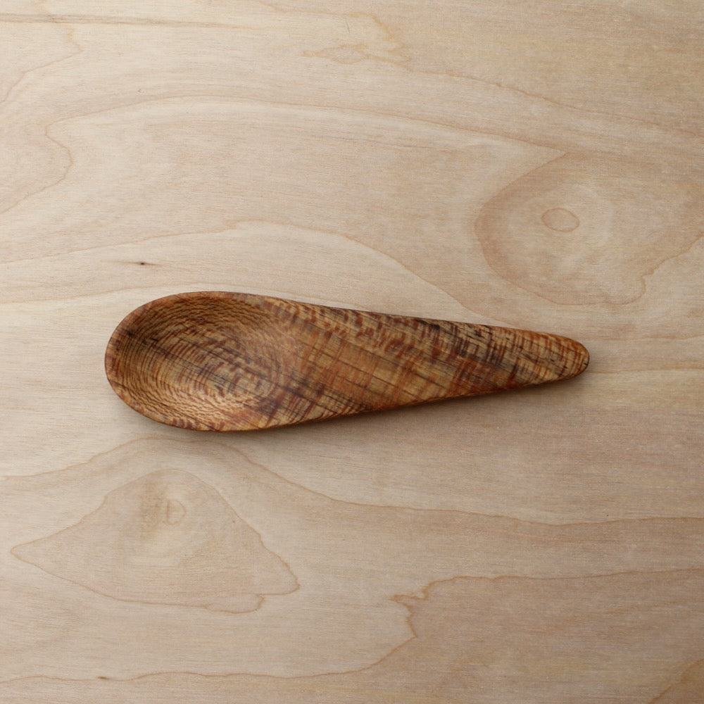 Wooden kayak spoon on a light wooden surface