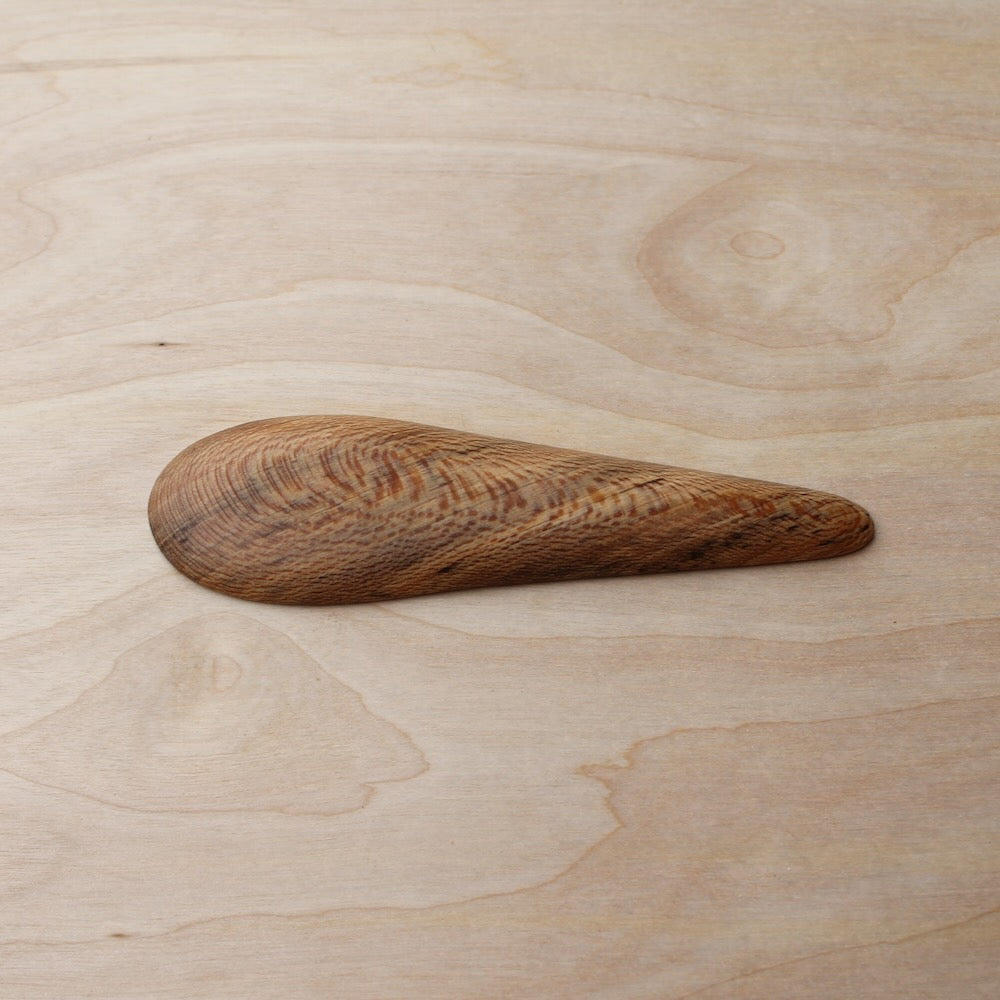 back of a wooden kayak spoon on a light wooden background
