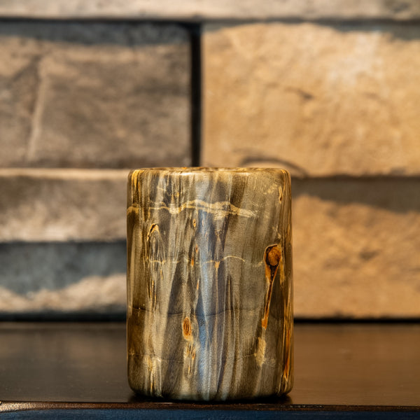 The Camo stabilized green Box Elder burl shot glass with prominent round natural knot and gold-orange figured grain