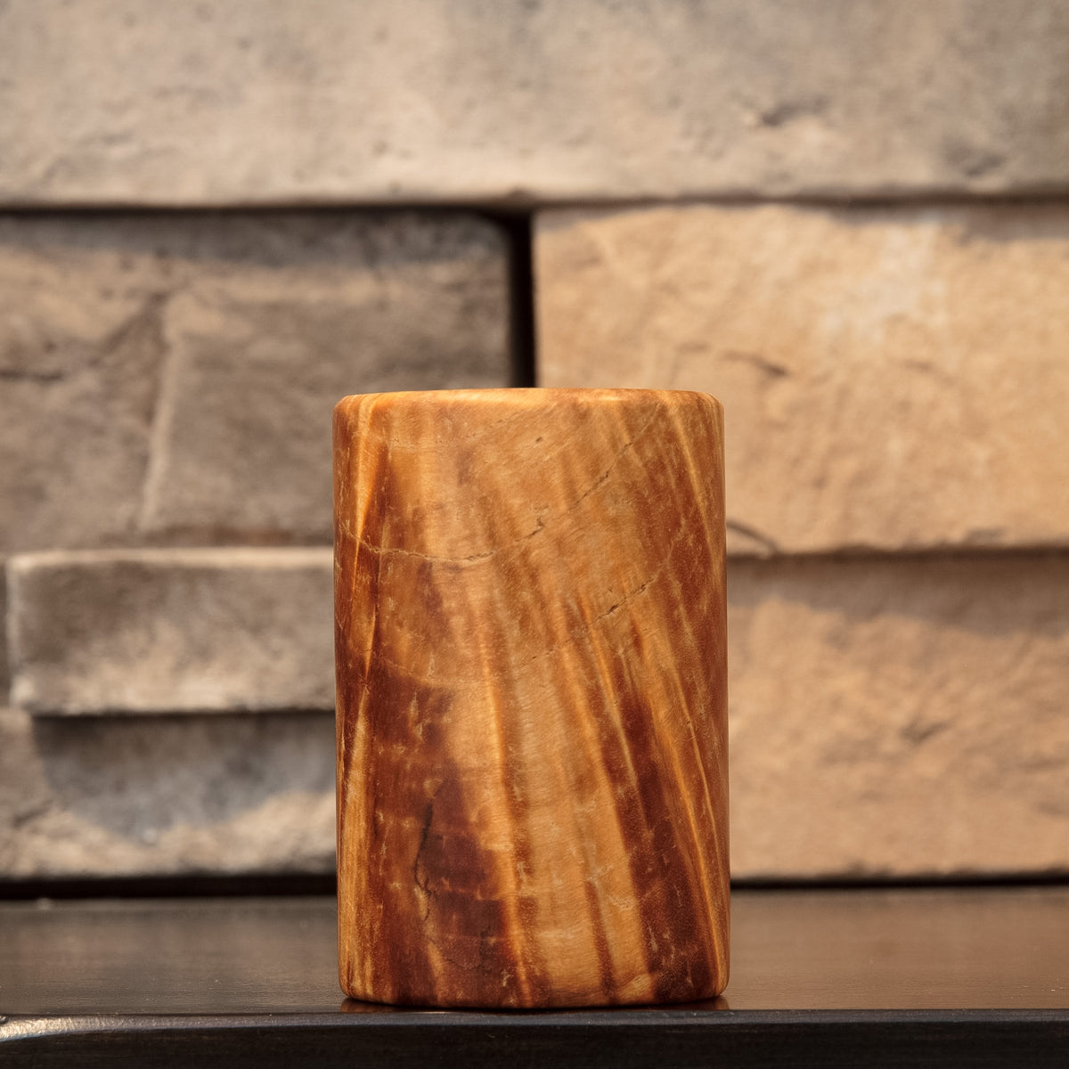 Rotated view showing flowing golden grain and natural dark lines across the stabilized burl