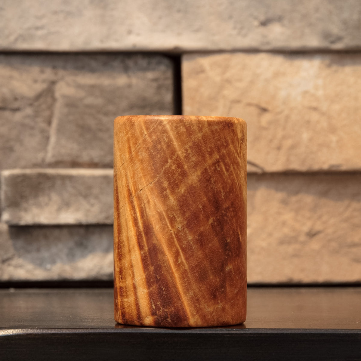 The Caramel Canyon shot glass with diagonal golden streaks crossing richly figured Box Elder burl