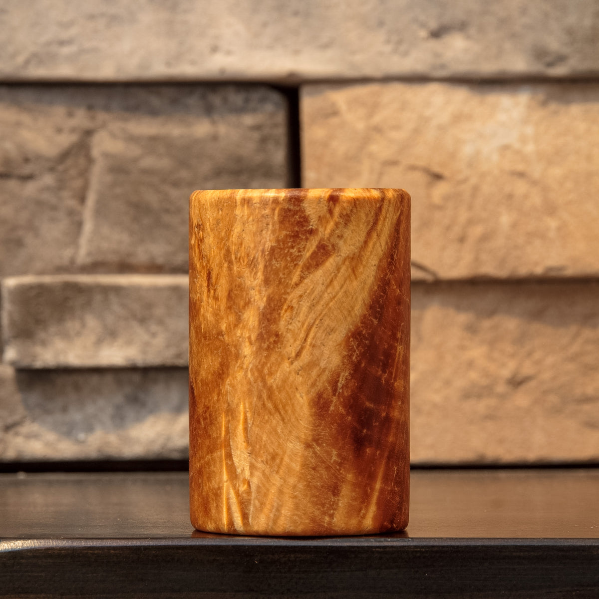 Side view of The Caramel Canyon showing golden burl figure framed by dark reddish-brown grain