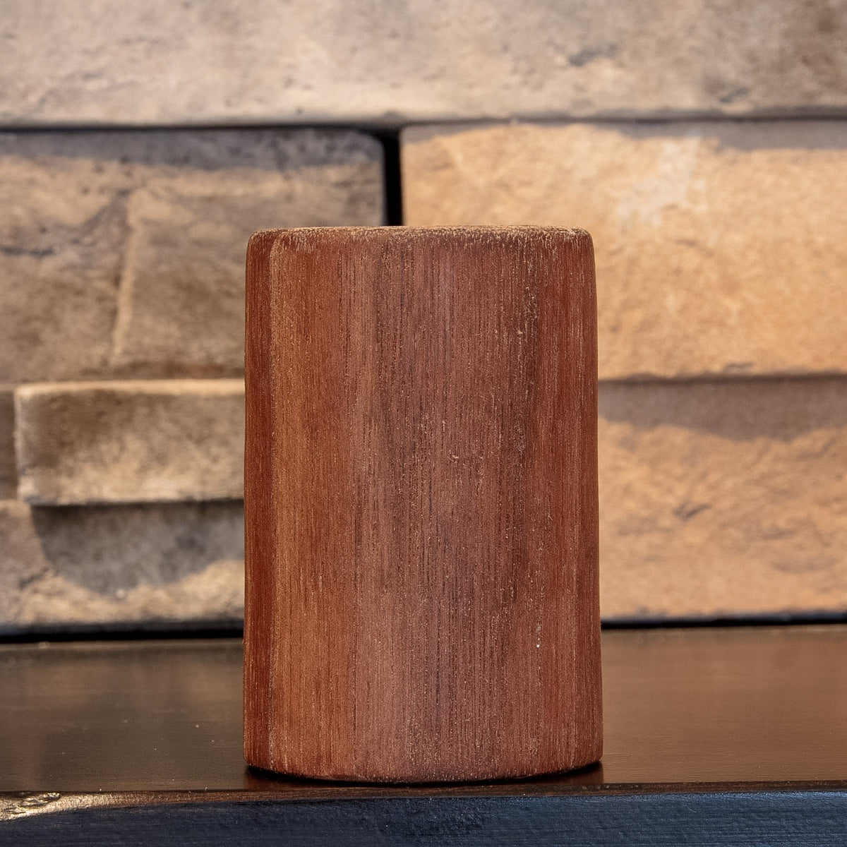 The Find walnut shot glass showing a quieter, evenly grained exterior face