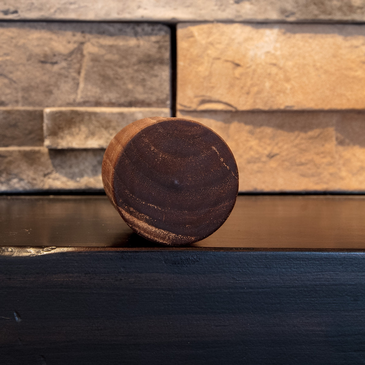 Bottom of The Find walnut shot glass showing dark circular end grain 