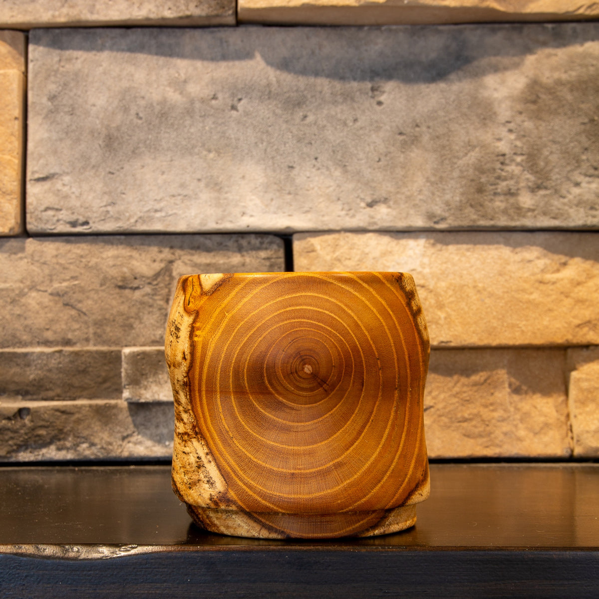 The Gathered Thread White Mulberry whiskey cup showing a centered face of concentric amber heartwood rings
