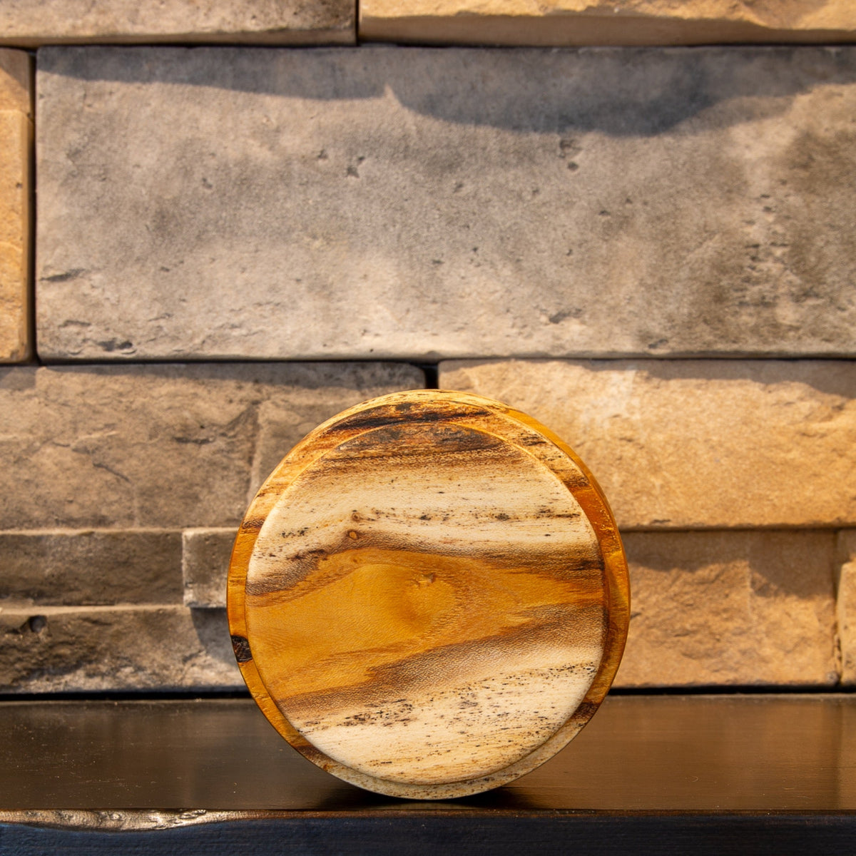 Bottom view of The Gathered Thread showing its circular foot and bands of pale sapwood and amber heartwood