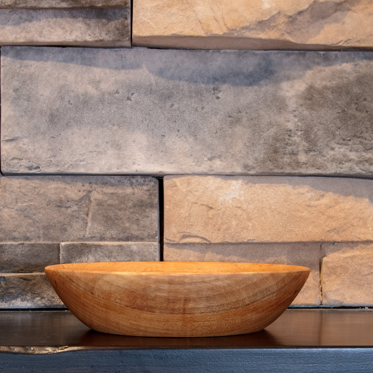 Alternate side of The Patient Grain pecan bowl showing its low curved form and flowing exterior grain