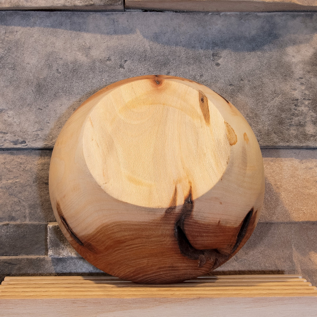Underside of The Space Between Sycamore bowl showing the turned base, pale grain, reddish figure, and natural openings