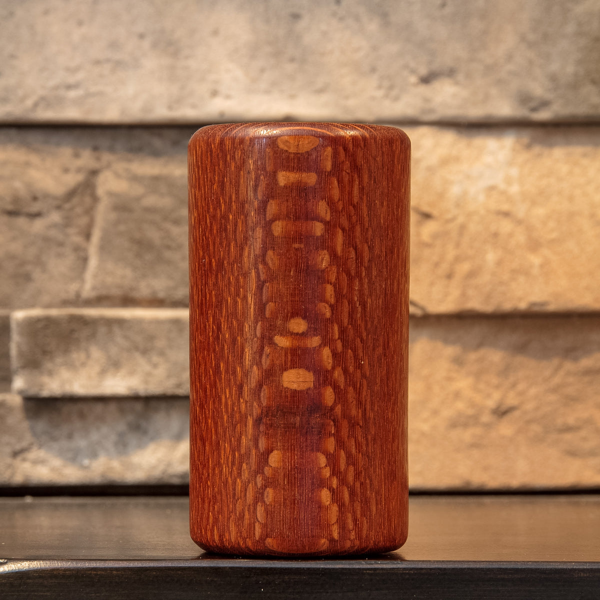 Front view of The Spotted Stalk leopardwood shot glass, showing a vertical band of pale spotted figure against reddish-brown grain.