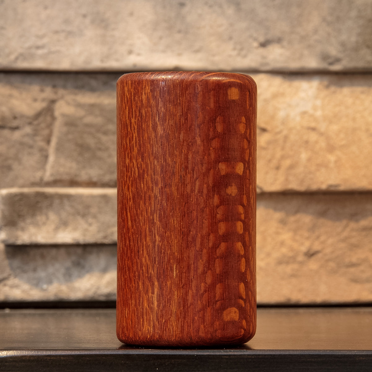 Angled exterior view of The Spotted Stalk leopardwood shot glass, highlighting contrasting pale spots and fine vertical grain.