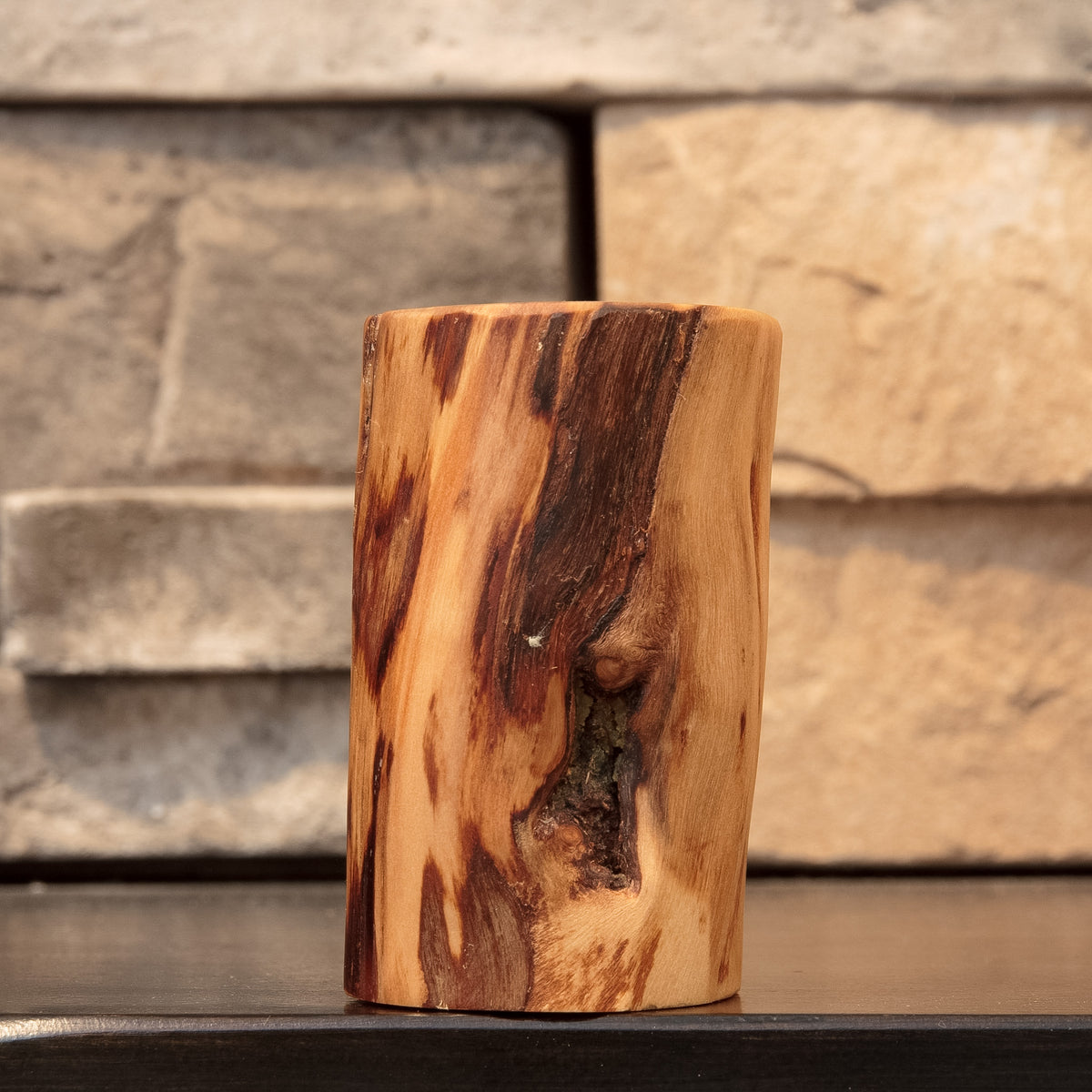 The Wild Branch hand-turned Colorado Plains Cottonwood shot glass showing natural bark inclusion, knot detail, and contrasting light and dark grain.
