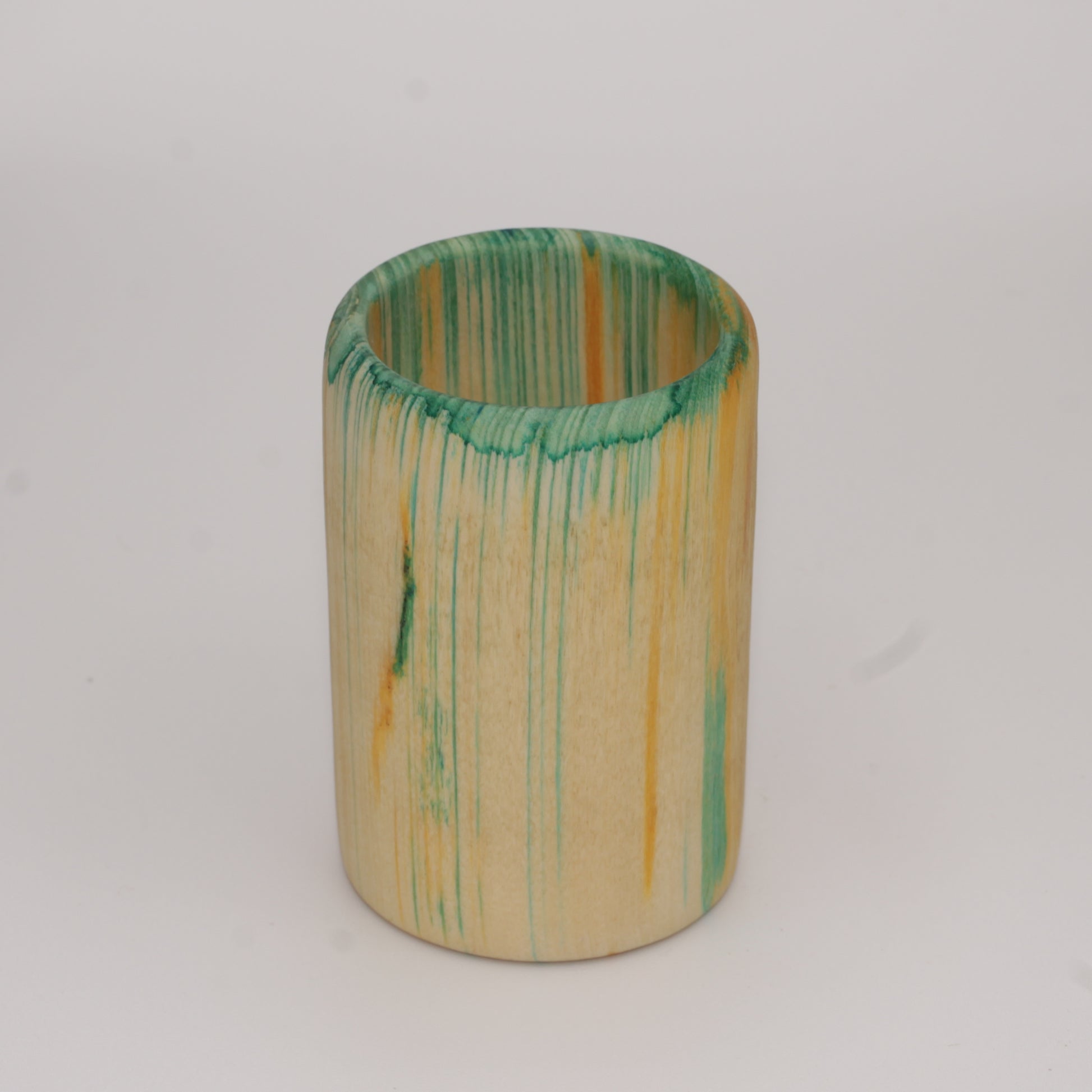Multicolored aspen wood shot glass against white background