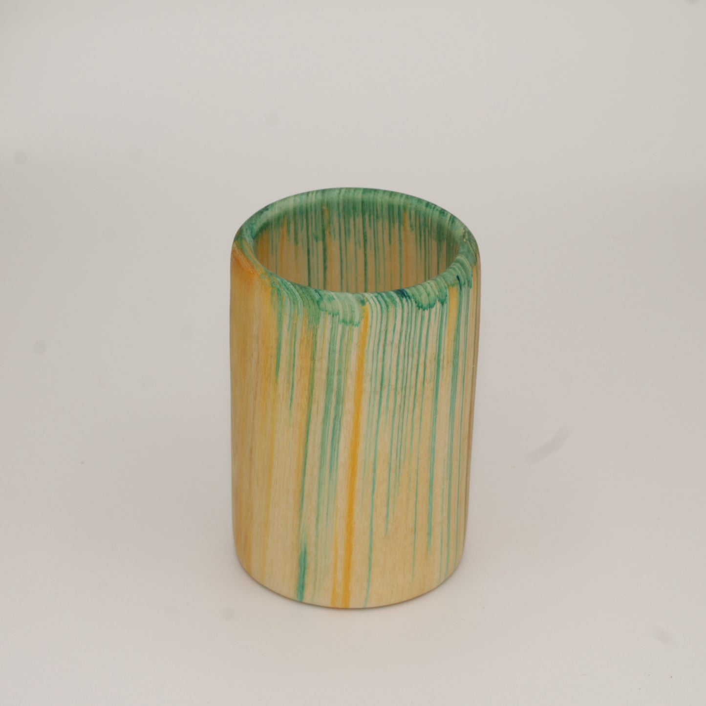 Multicolored aspen wood shot glass against white background