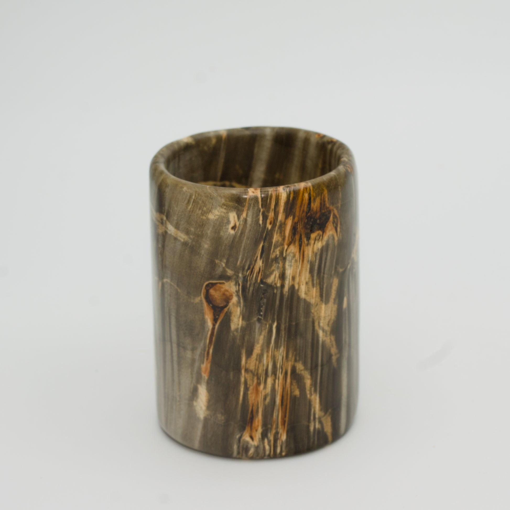 Green boxer elder burl shot glass against white background
