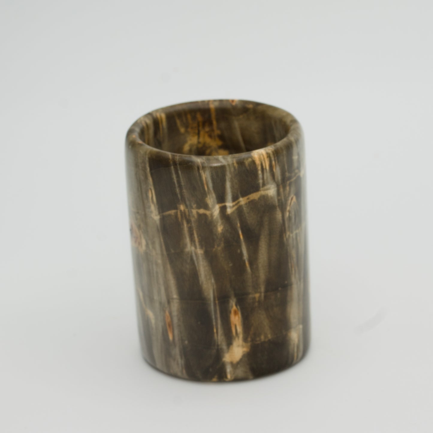 Green boxer elder burl shot glass against white background
