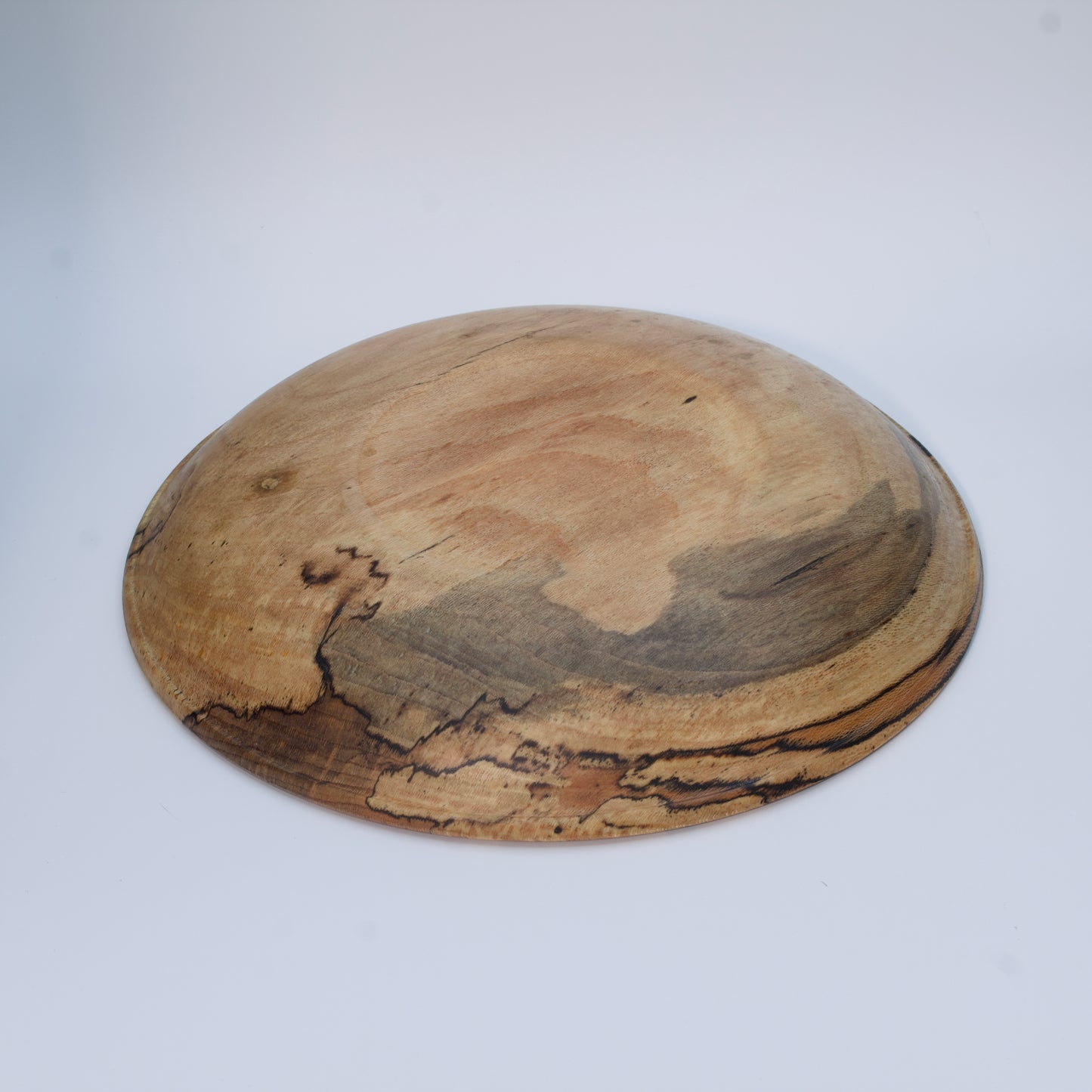 Wooden bowl with marbled pattern on a white background