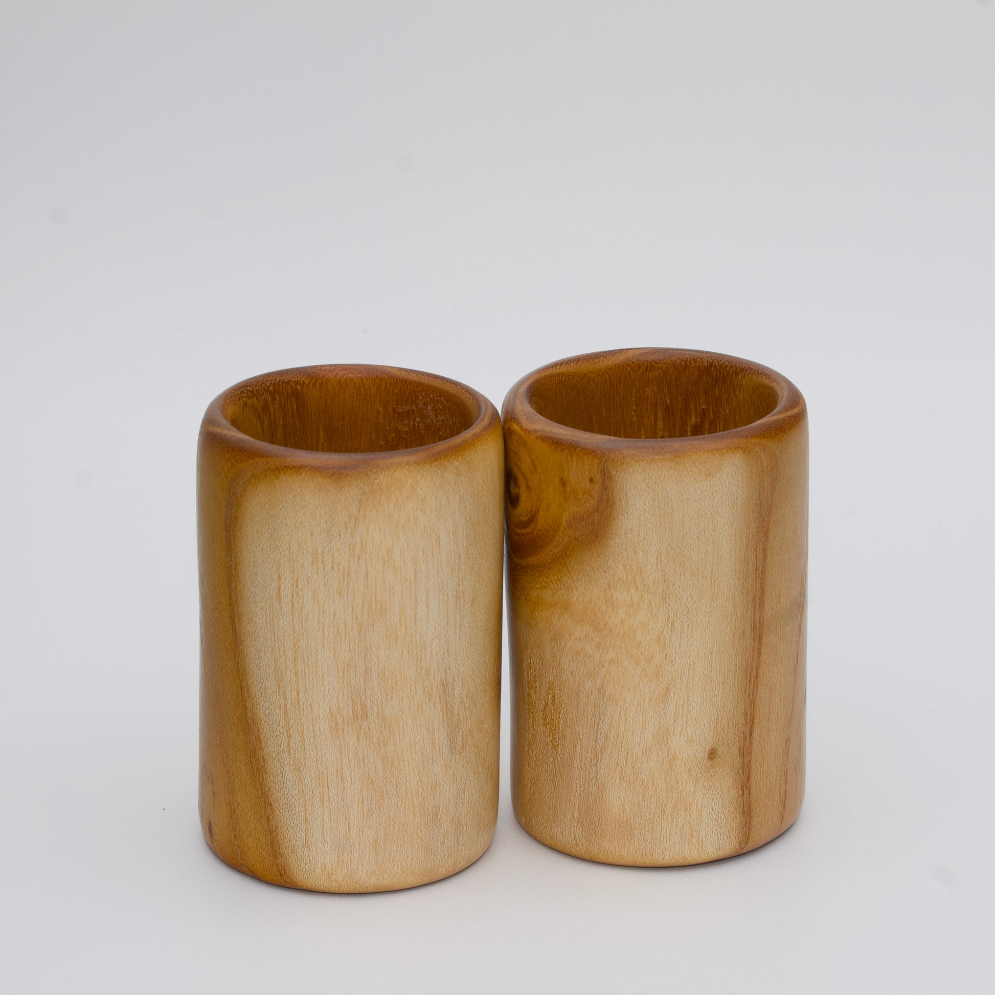 Pair of white mulberry shot glasses with orange glow