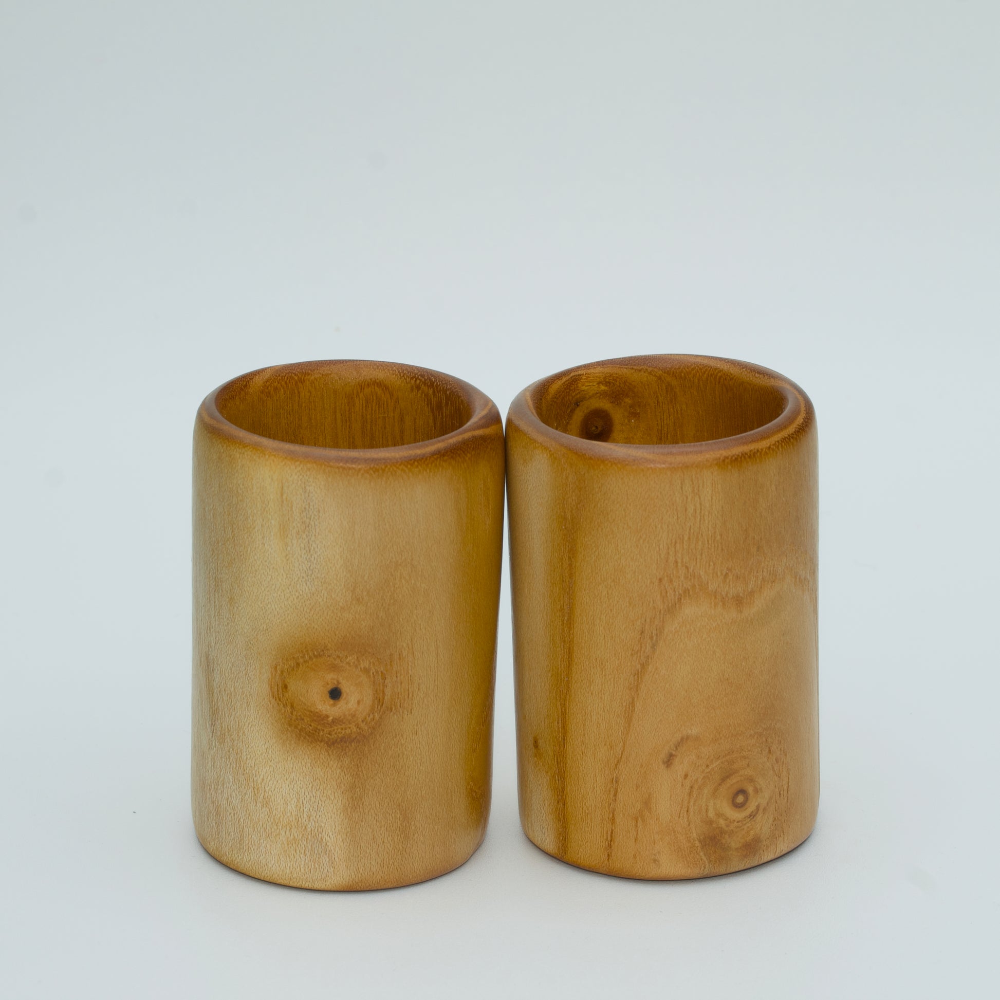 Pair of white mulberry shot glasses with orange glow