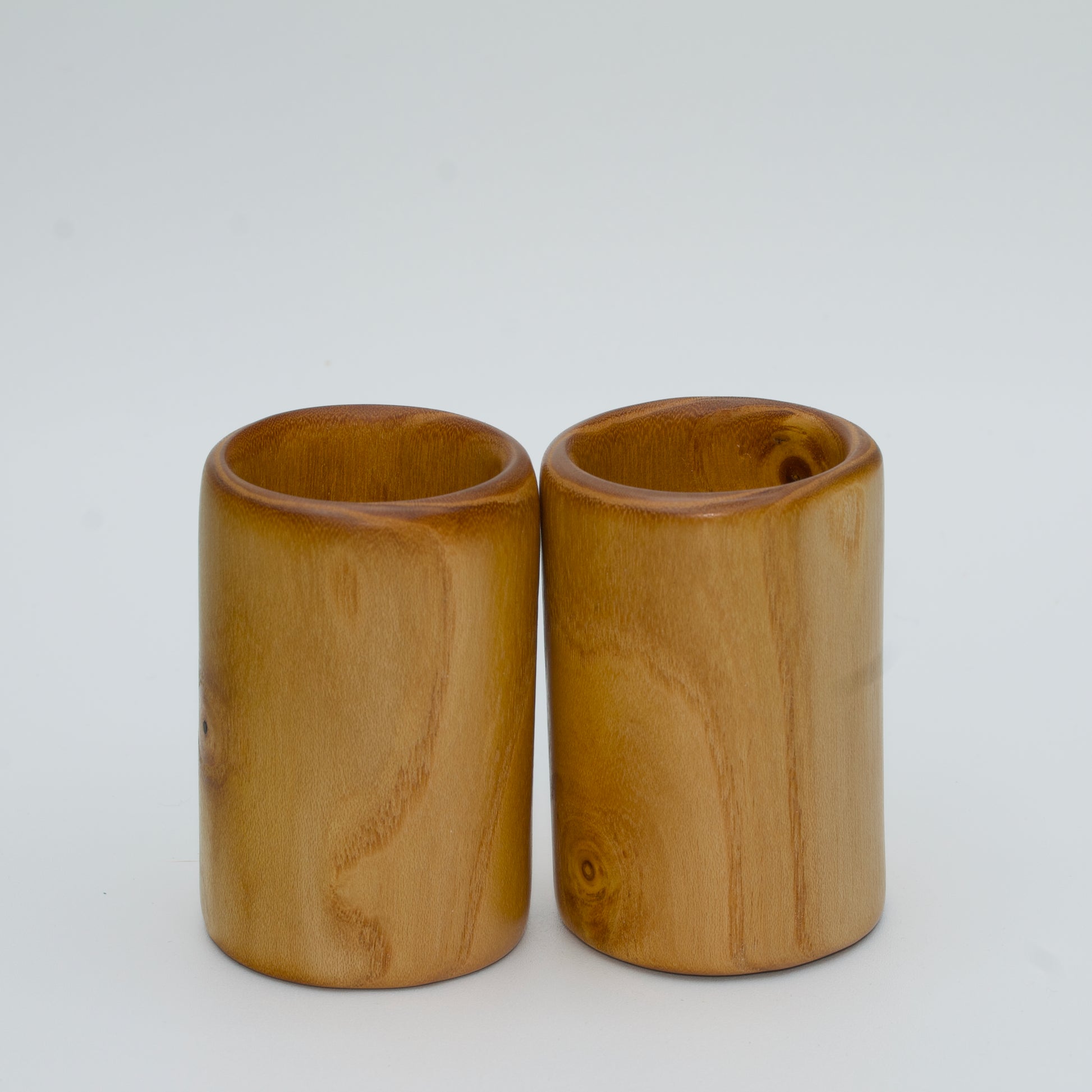 Pair of white mulberry shot glasses with orange glow