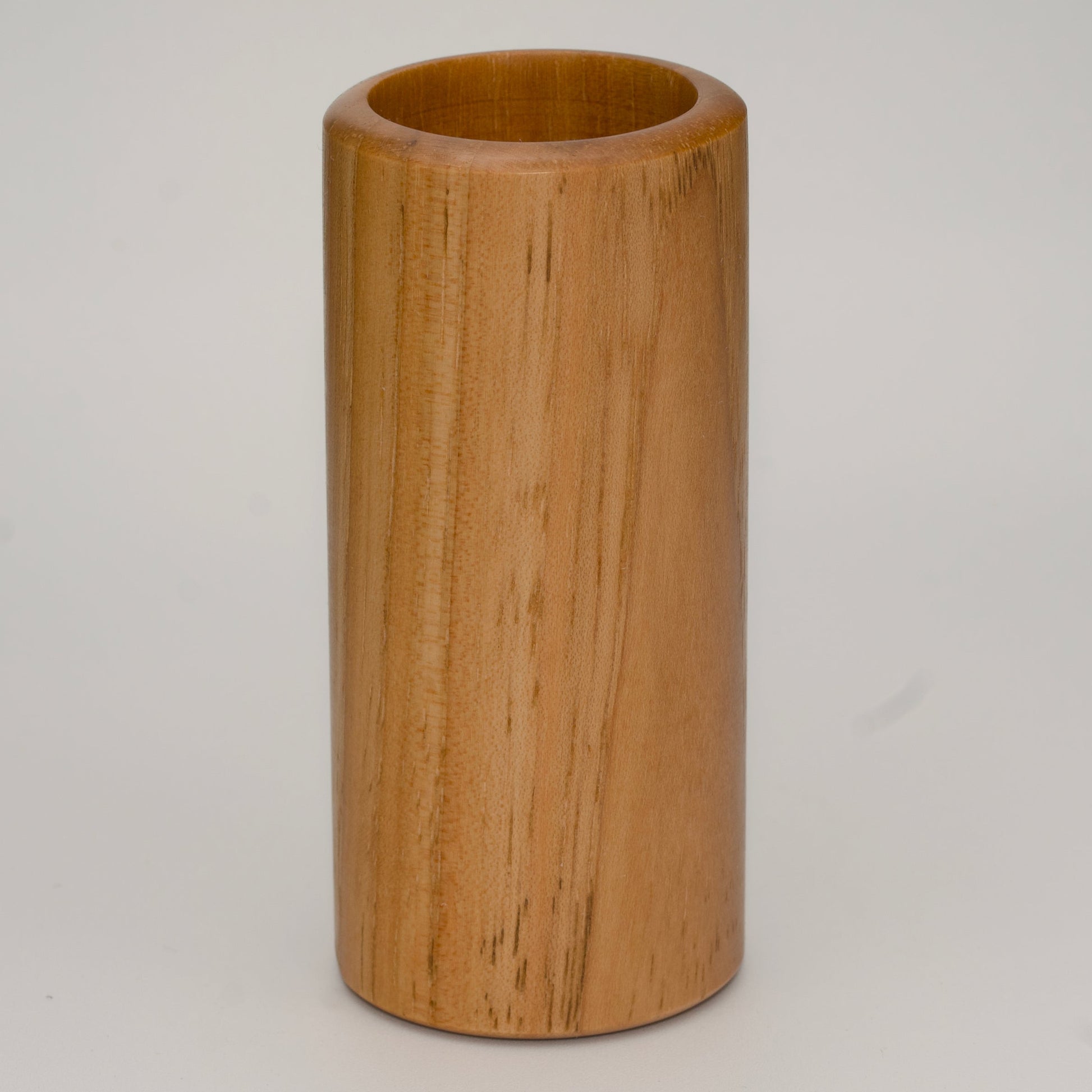 Tall pecan wood shot glass against white background