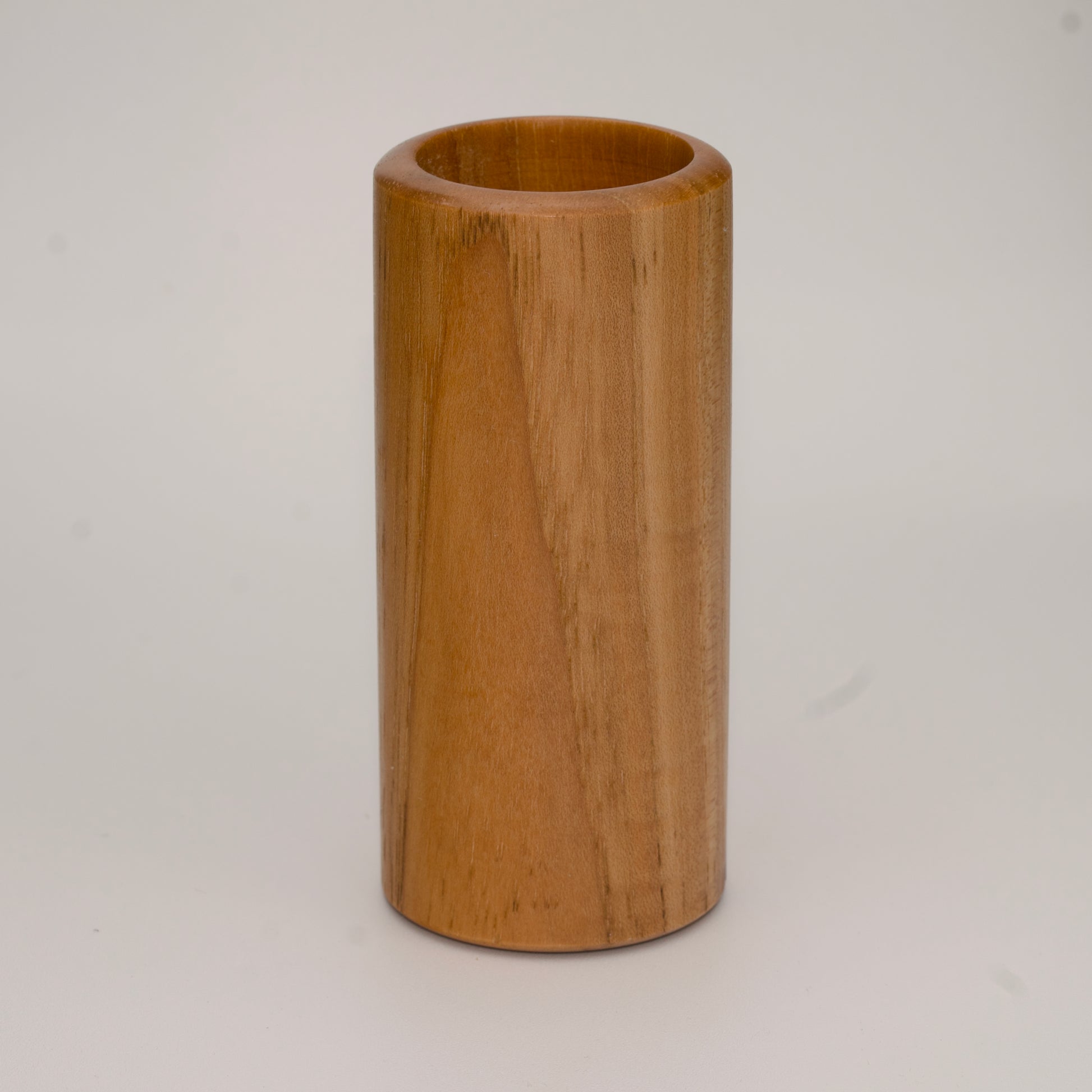 Tall pecan wood shot glass against white background
