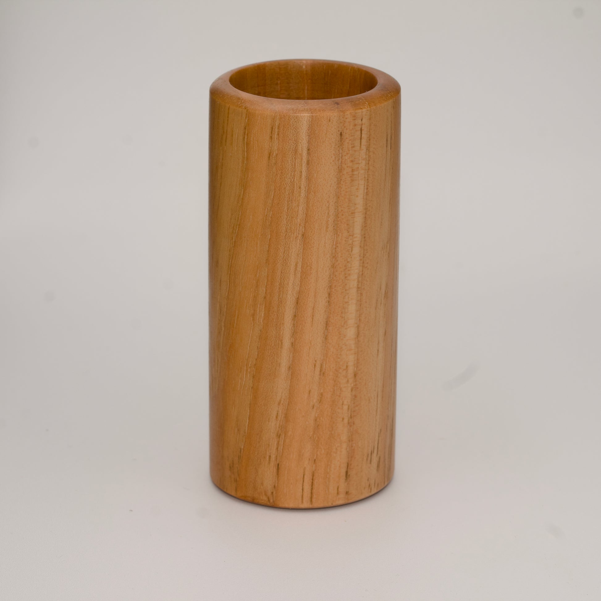 Tall pecan wood shot glass against white background
