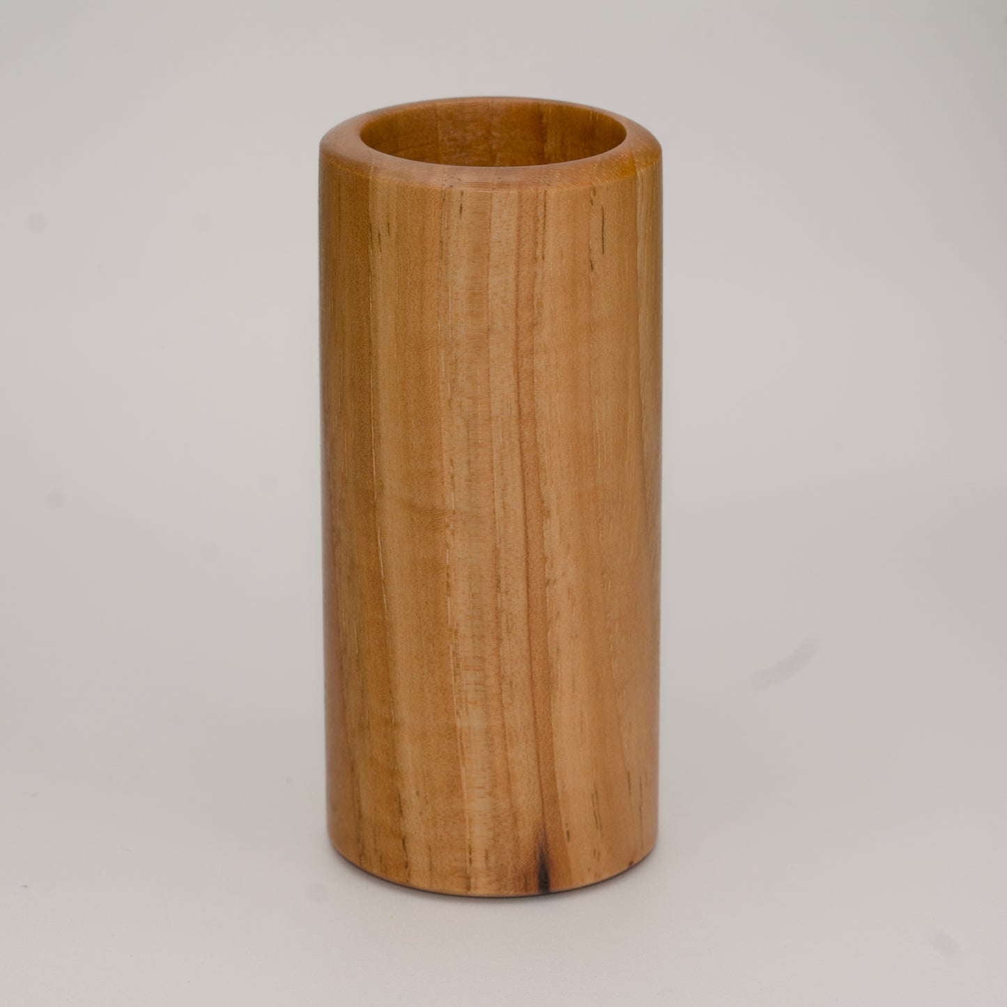 Tall pecan wood shot glass against white background