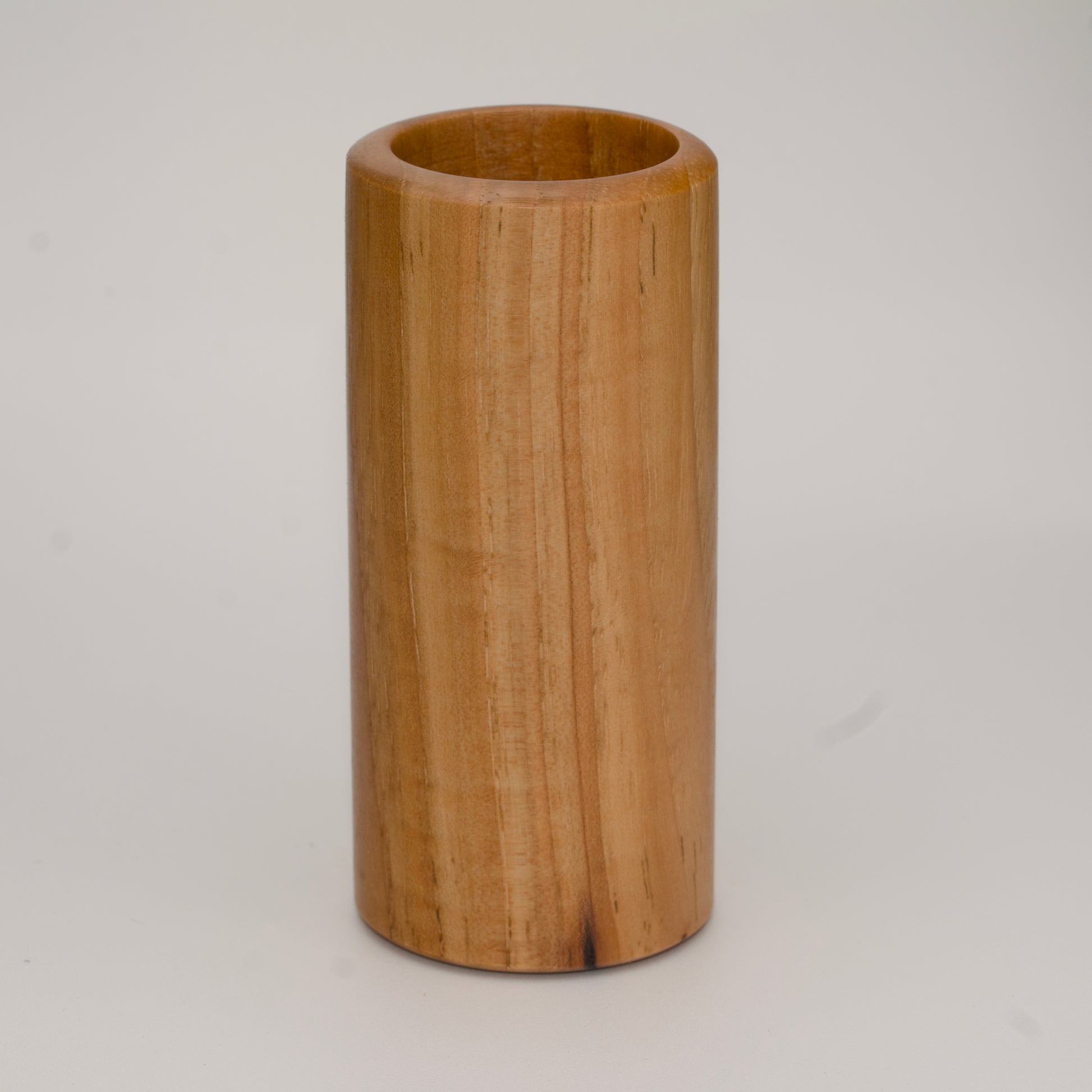 Tall pecan wood shot glass against white background