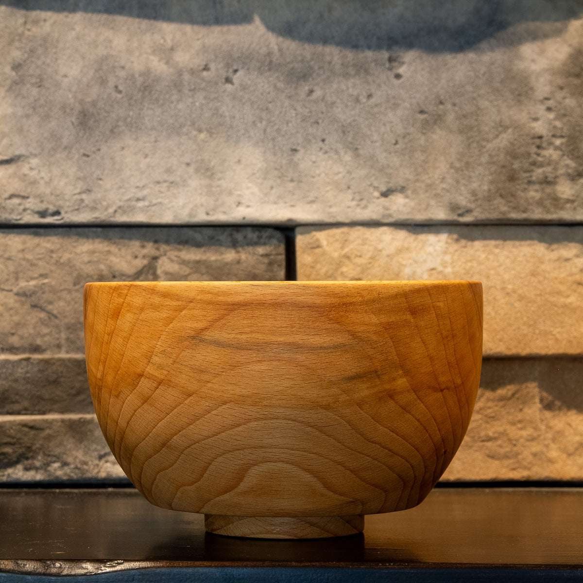 Exterior view of The Alabaster Basin European Beech bowl showing centered flowing grain