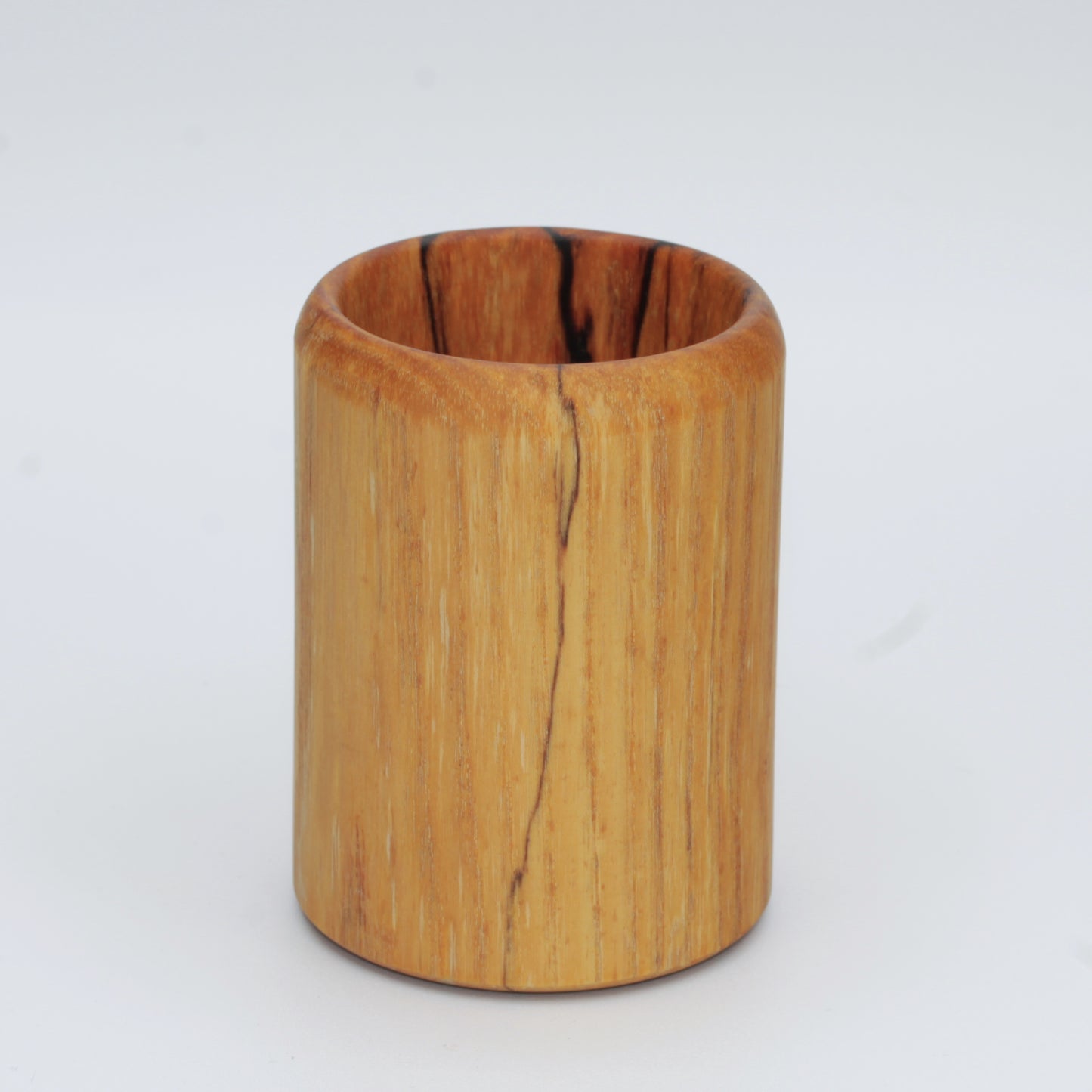 yellow wooden cup with back and white markings like a banana slug