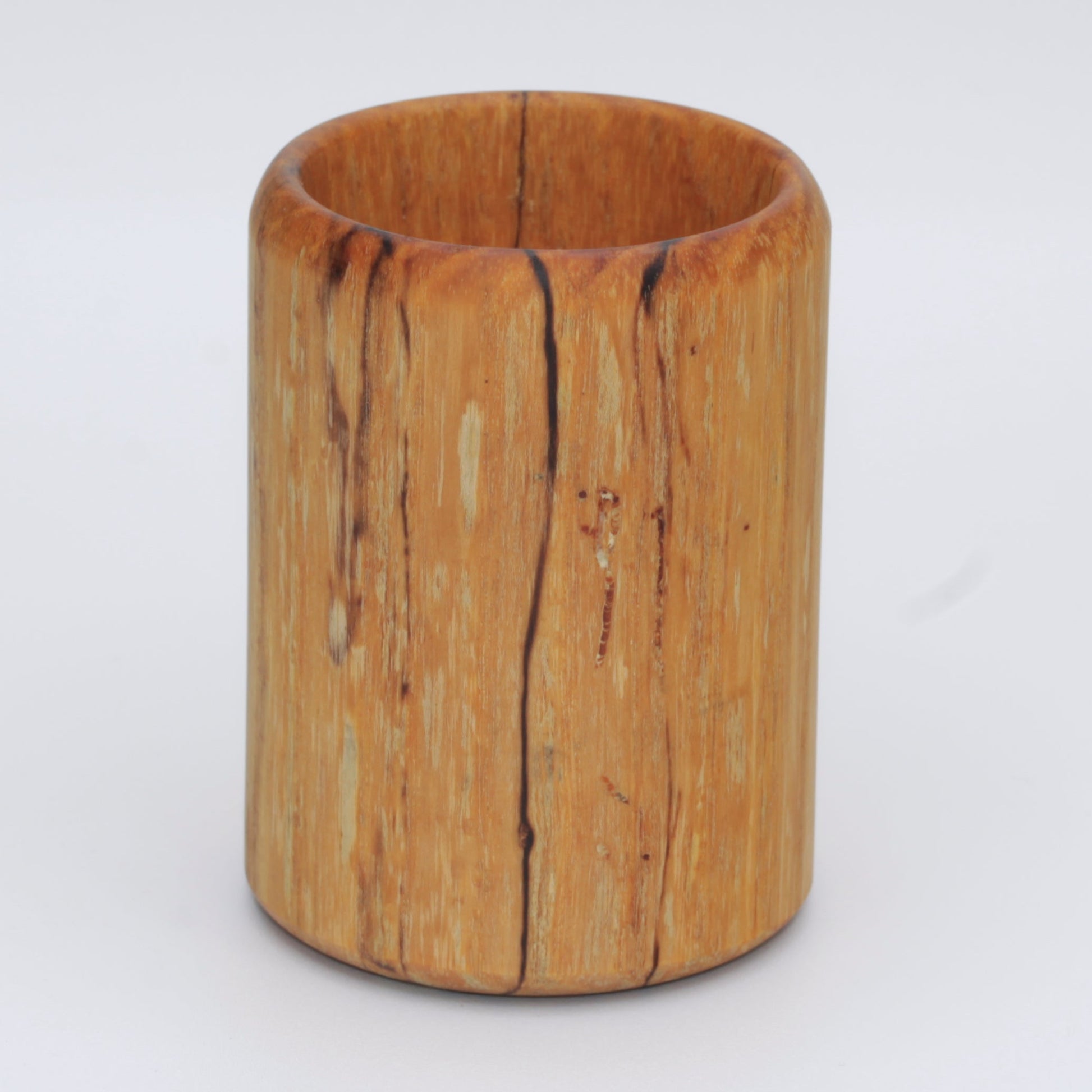 yellow wooden cup with back and white markings like a banana slug