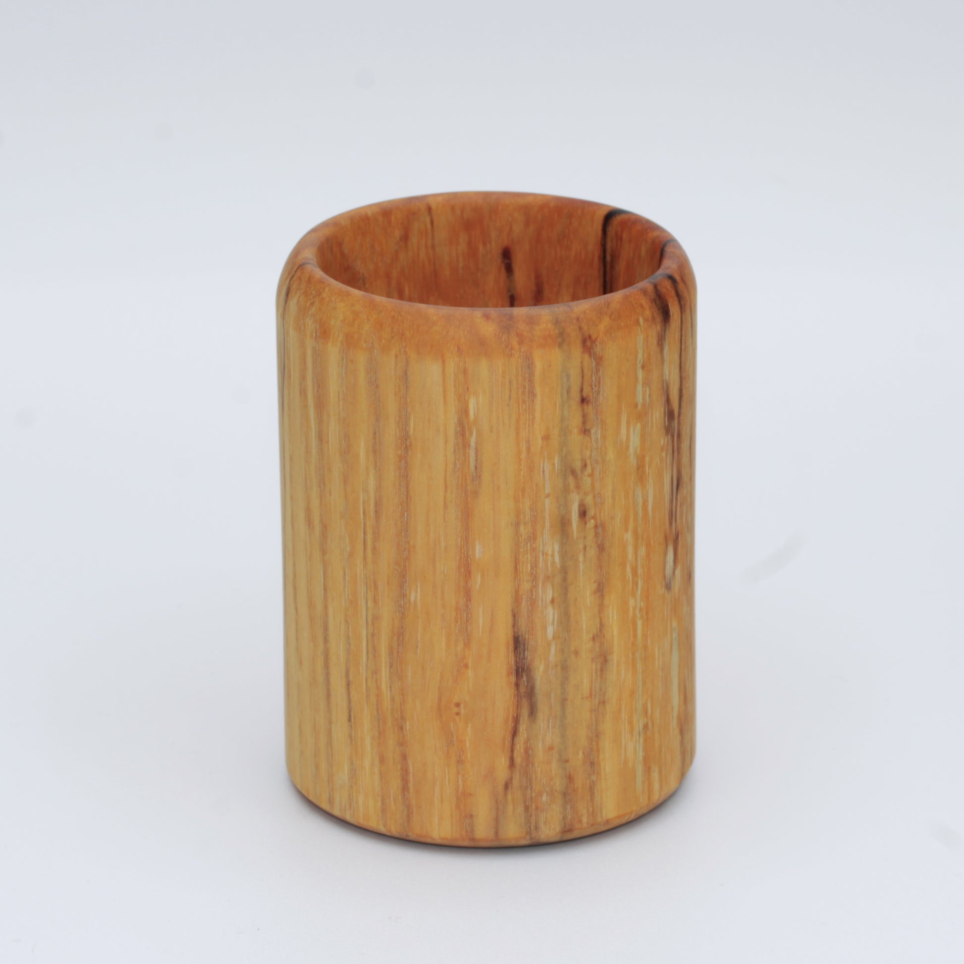 yellow wooden cup with back and white markings like a banana slug