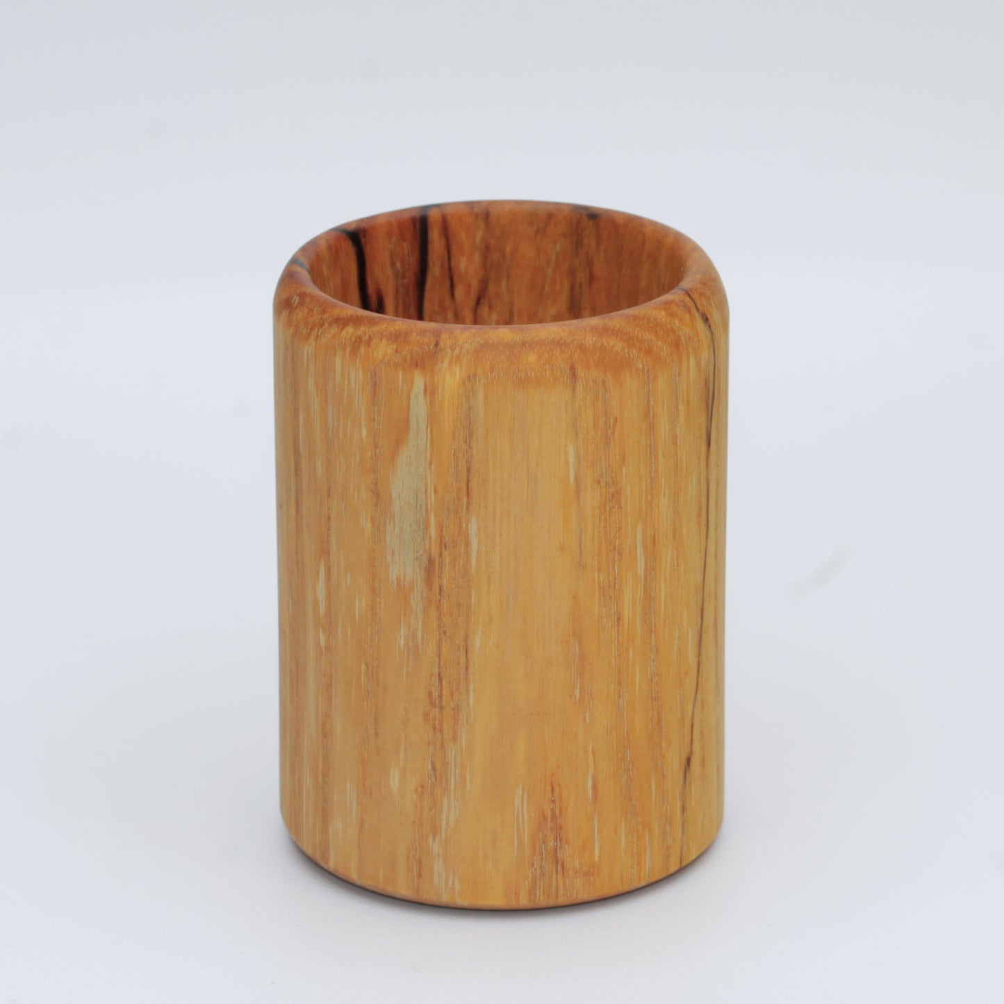 yellow wooden cup with back and white markings like a banana slug