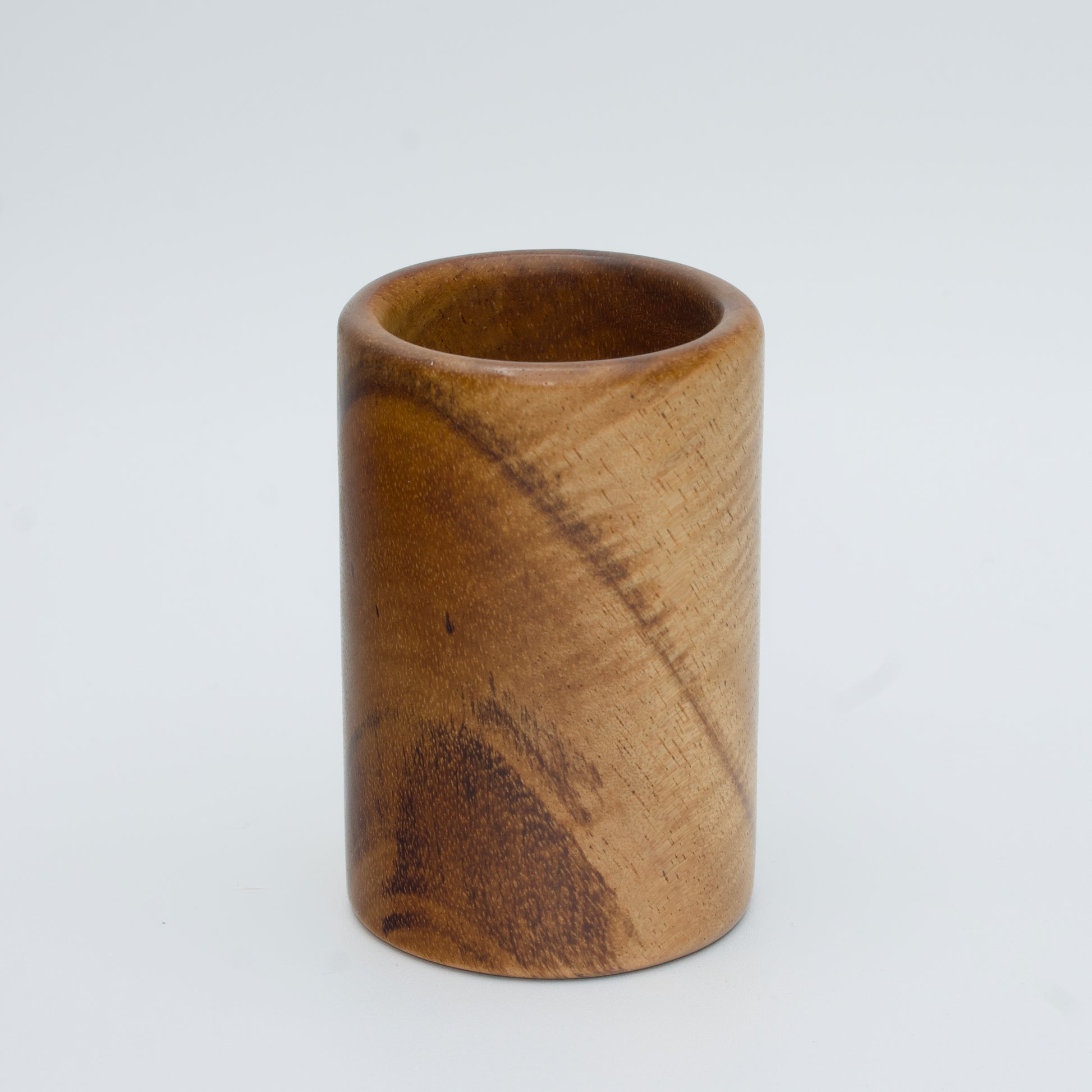 Acacia wood shot glass against white background