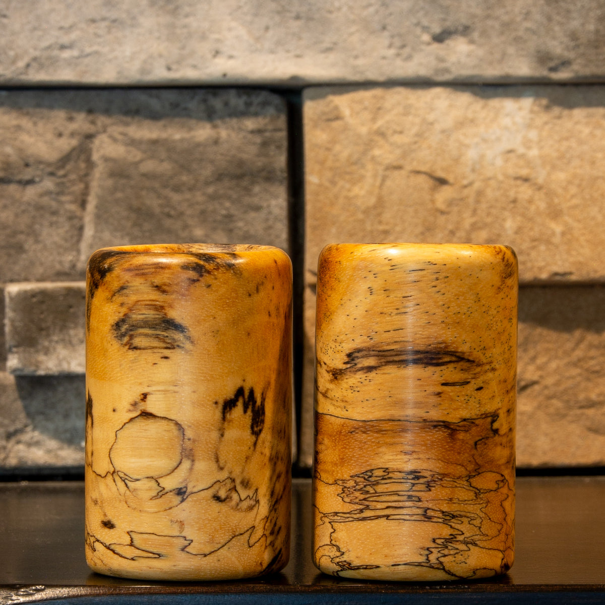 The Comic Duo stabilized Spalted Tamarind shot glass pair showing light golden wood and intricate black spalted linework