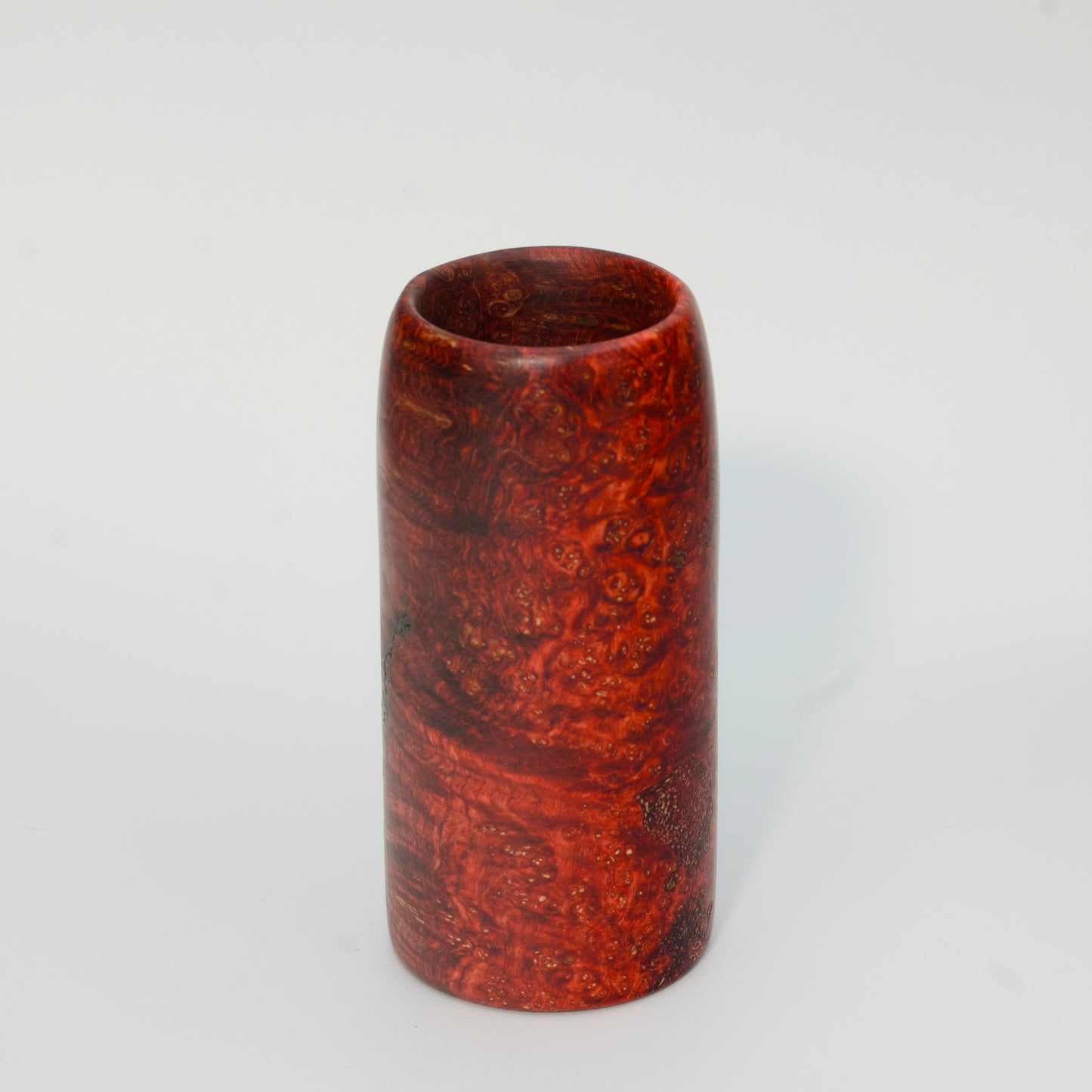 Red amboyna burl shot glass against white background